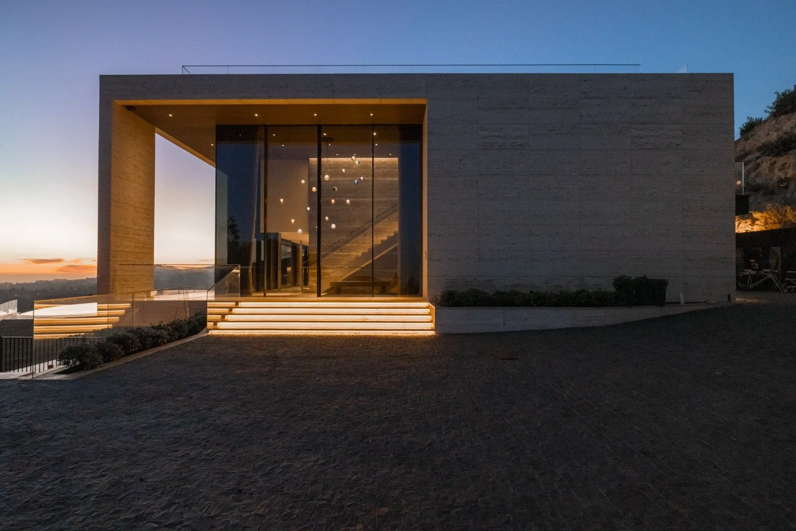 684-Firth-Brentwood-CA-LA-Exterior-Front-Entry-Travertine-Box-Glass-Facade-Dusk-Roderick-Builders-Modern-Home.JPG