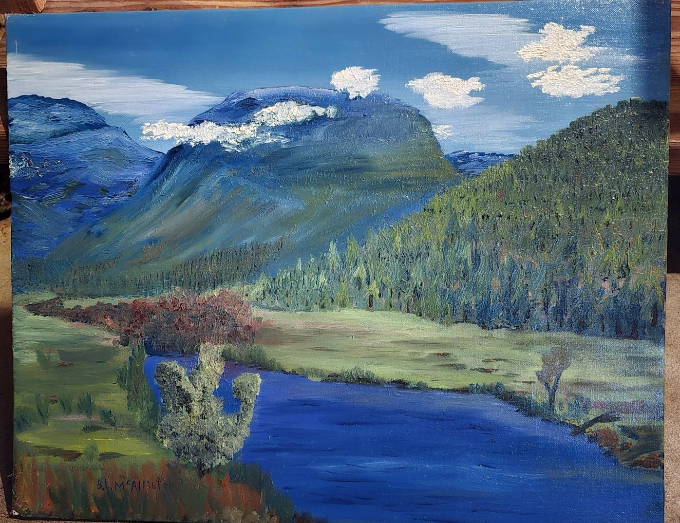 A landscape painting of mountains, a blue river, and lush green trees and grass, with a cloudy sky above.