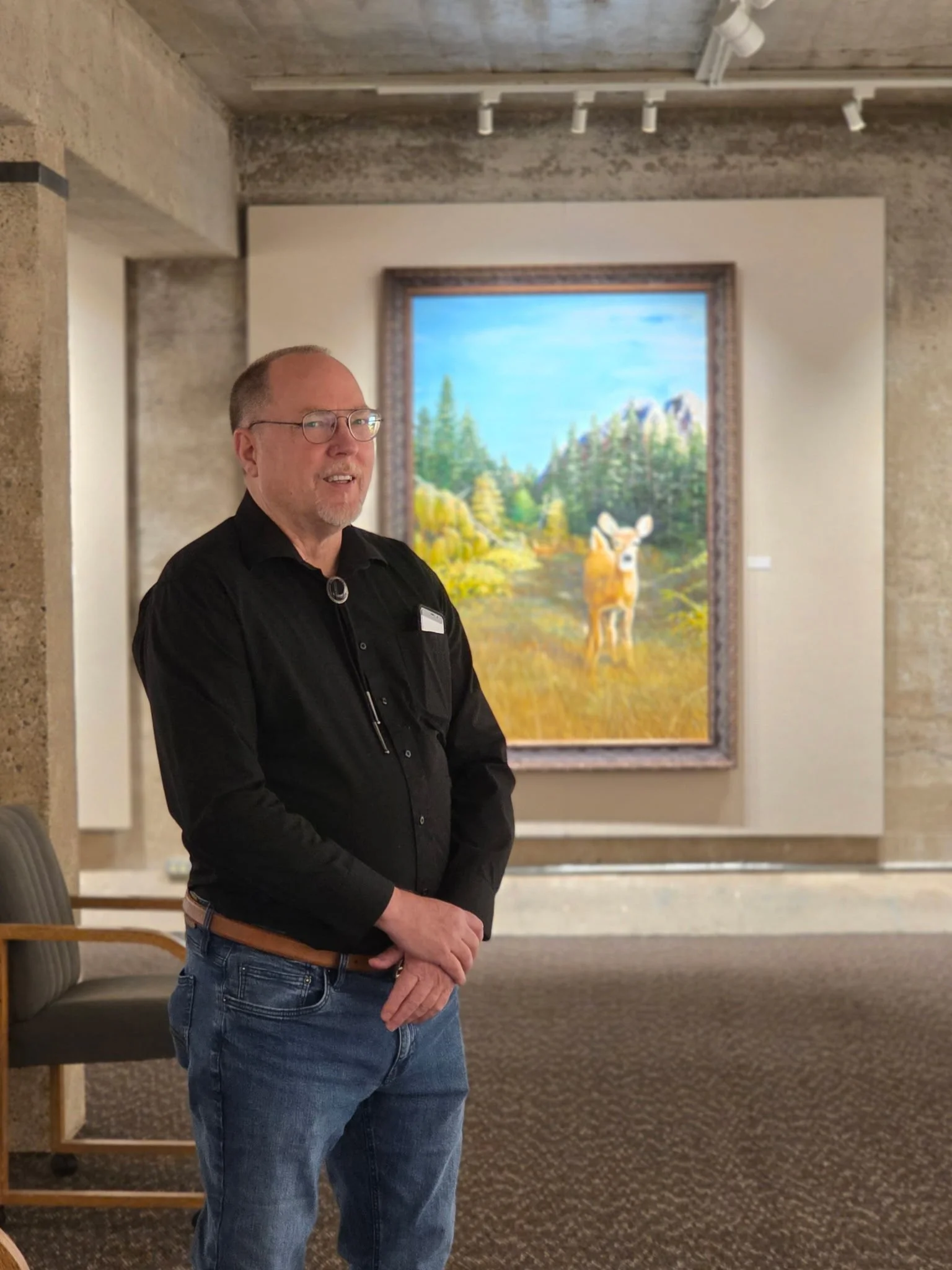 Galen 'Mac' McAllister in front of his large landscape painting "Rita" in the Waterworks Art Museum in Miles City, Montana