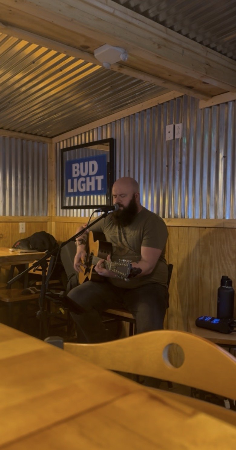Corey Snowden, bearded musician, preforming live acoustic guitar set and singing in Trail 10 Pub & Grill in Freemen, WV.