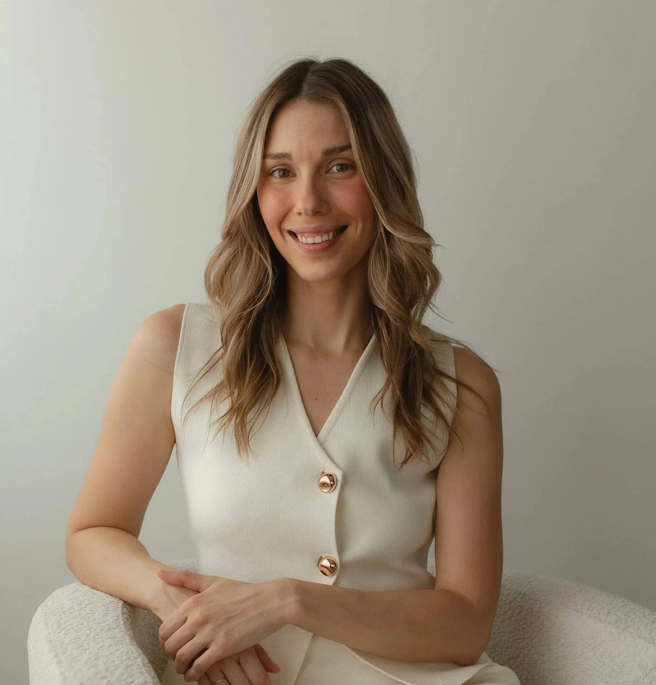 Emilija Matas, Vancouver interior designer, smiling in a cream vest