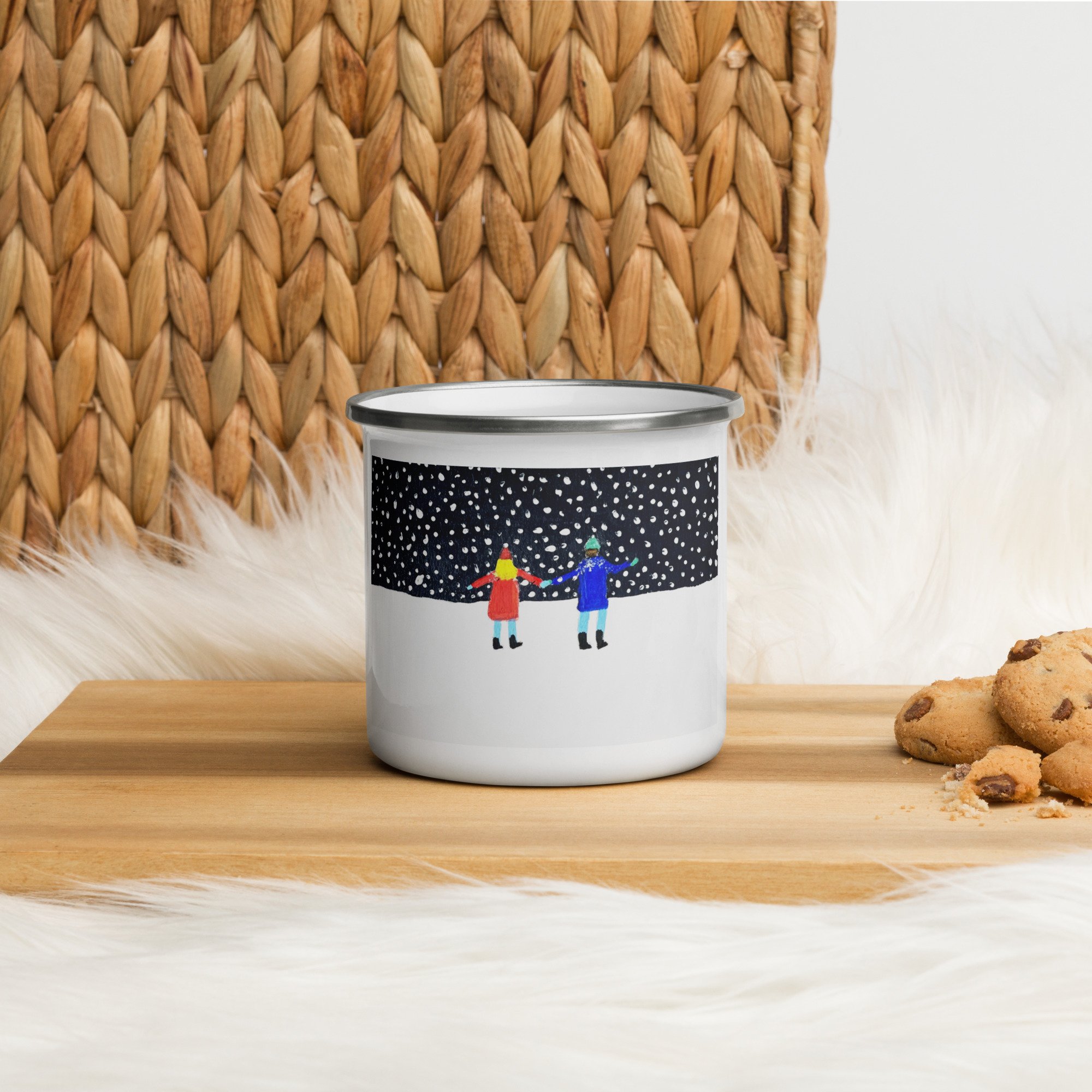 White enamel mug with snowy scene on it sitting on a cutting board