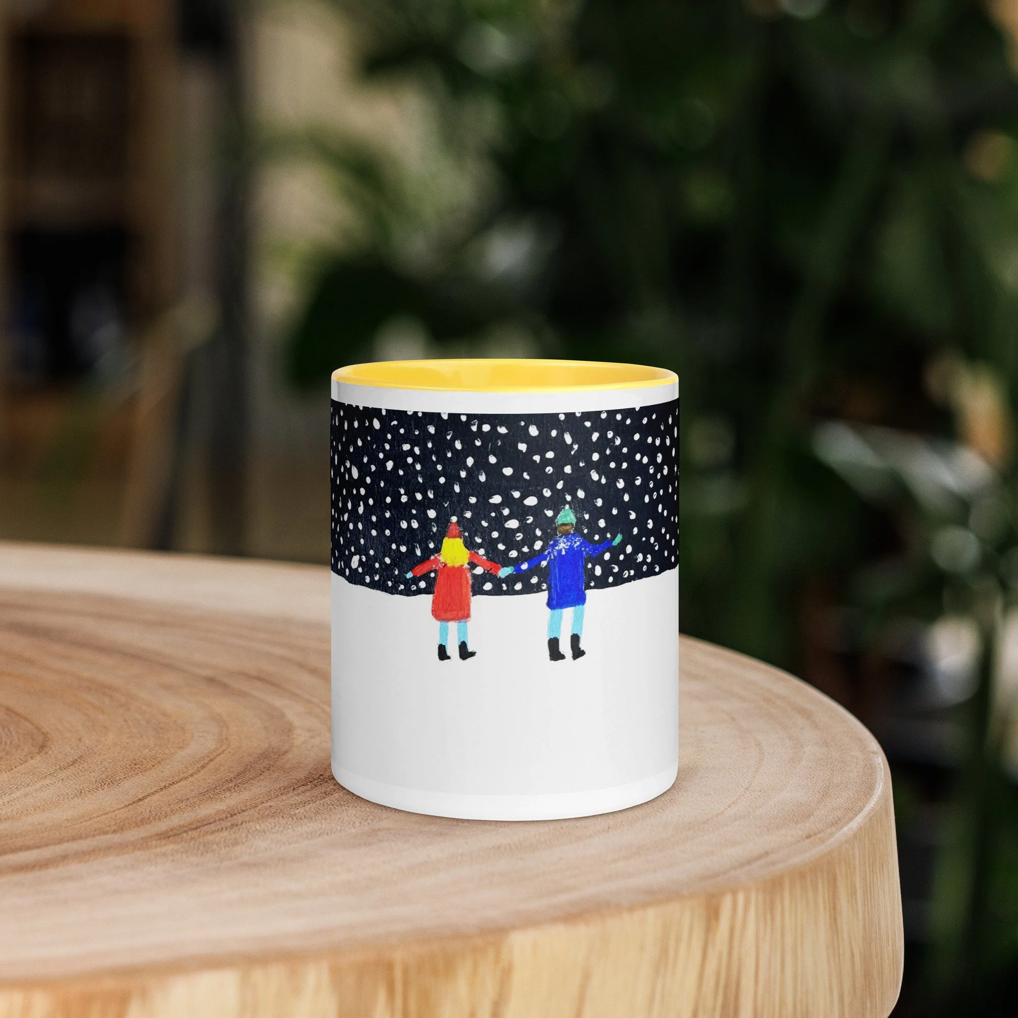 White ceramic mug with a yellow interior, with a couple in a snowy scene illustration