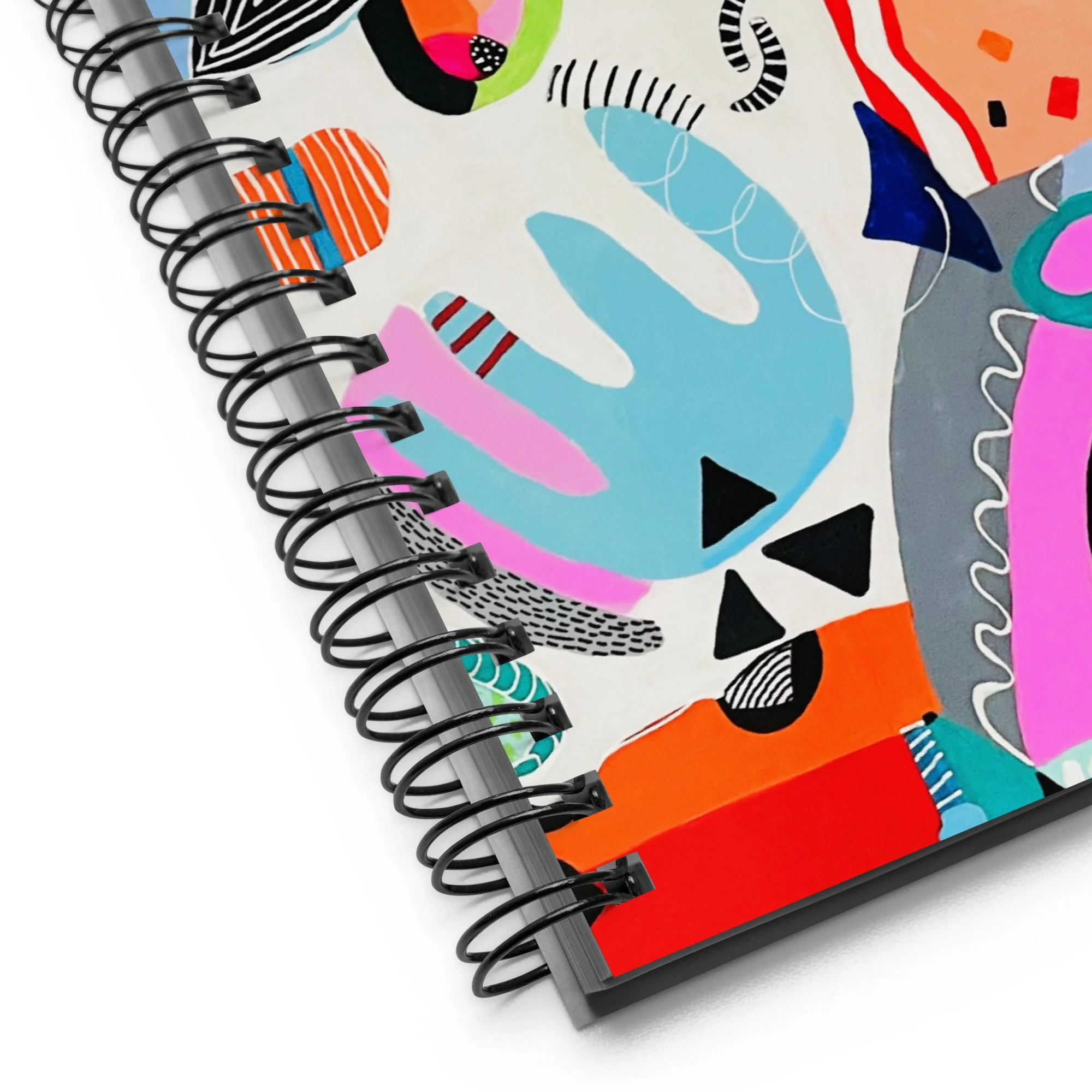 spiral notebook with colorful "synchronicity" art applied to the cover