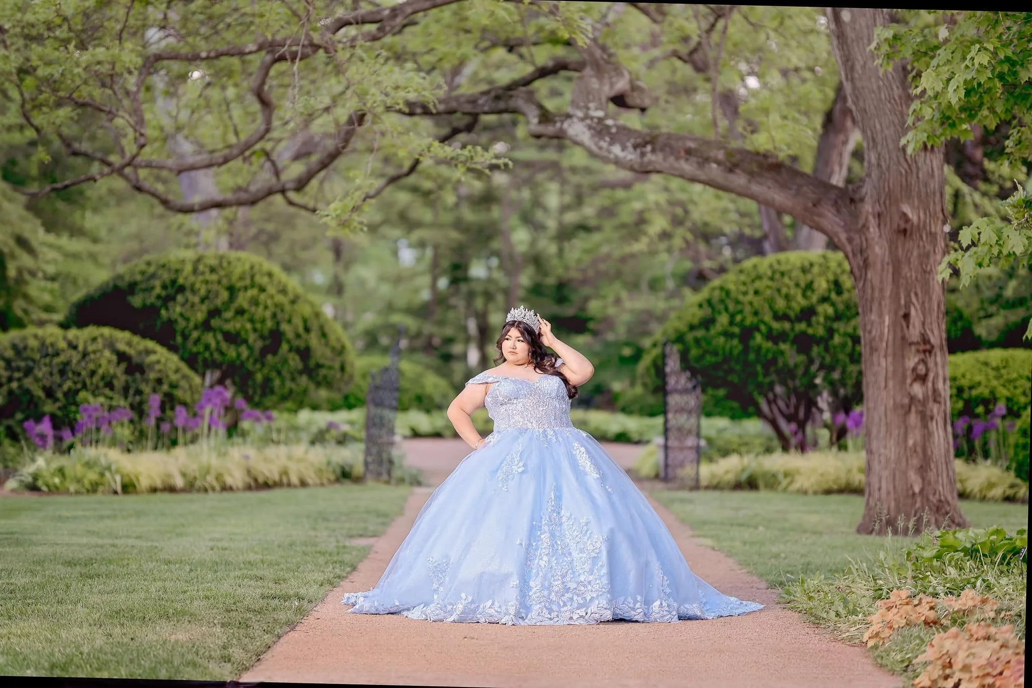 Regal quinceañera in a blue ball gown during a photoshoot at Cantigny Park in Wheaton, Illinois.