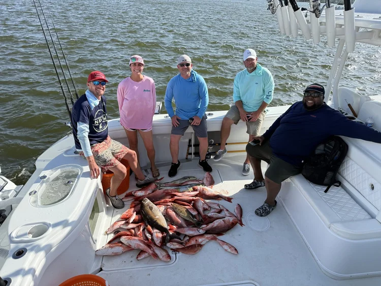 Five anglers on deck around the day's catch