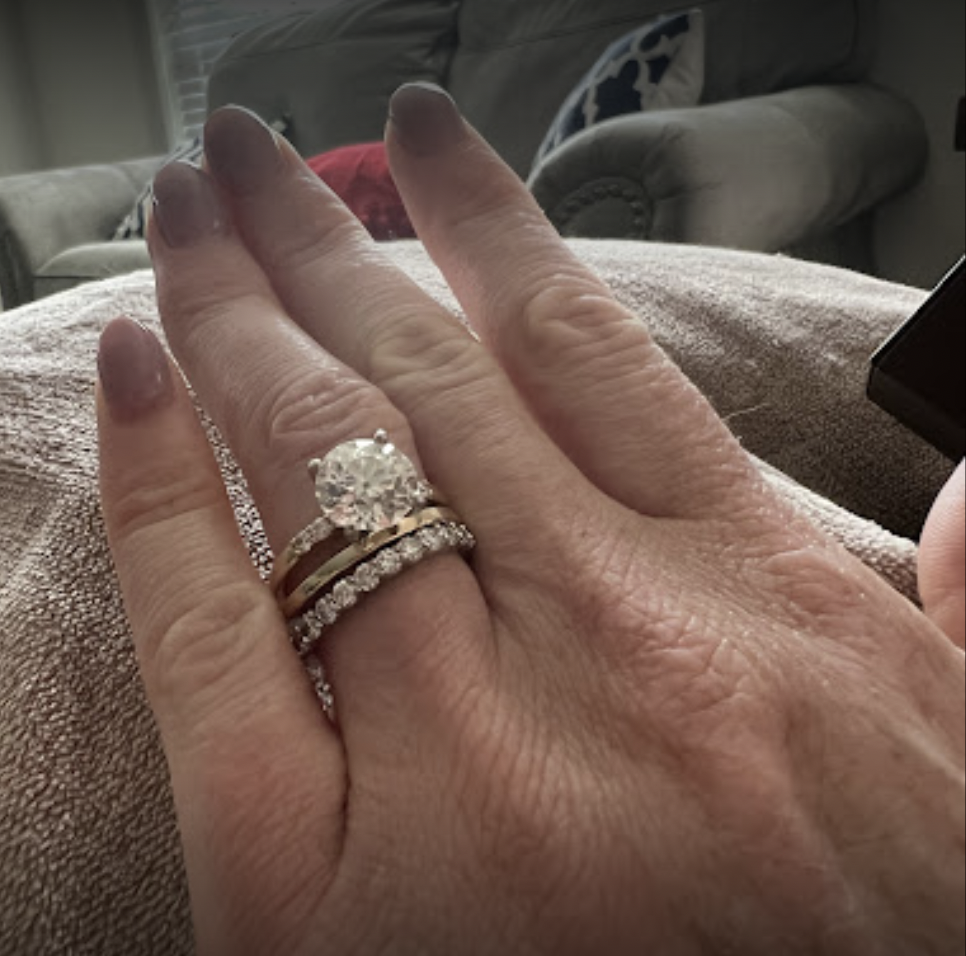 Close-up of a hand wearing wedding and engagement rings