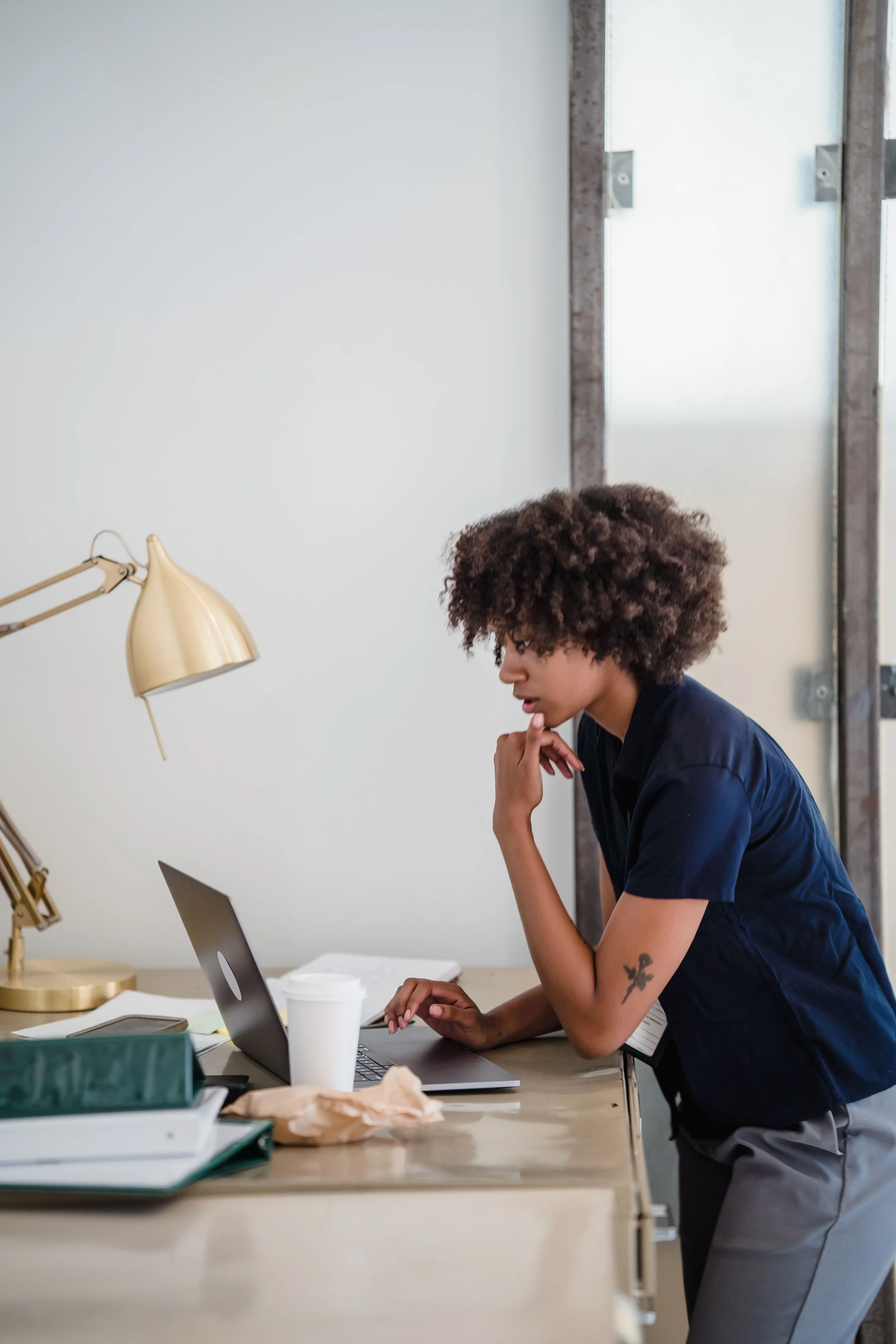 Woman standing at a desk working on a computer