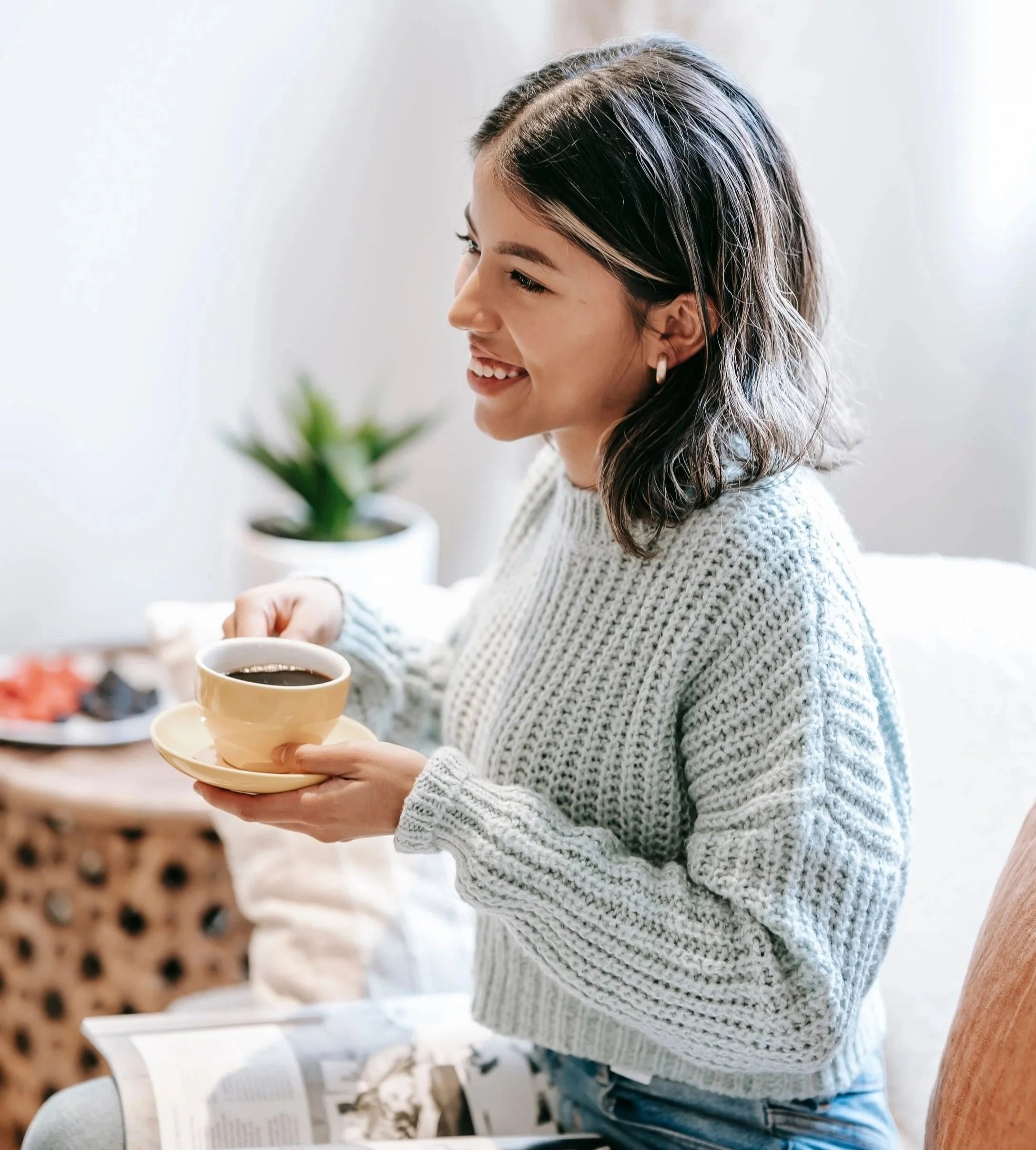 Smiling woman , sitting and holding a cup of coffee