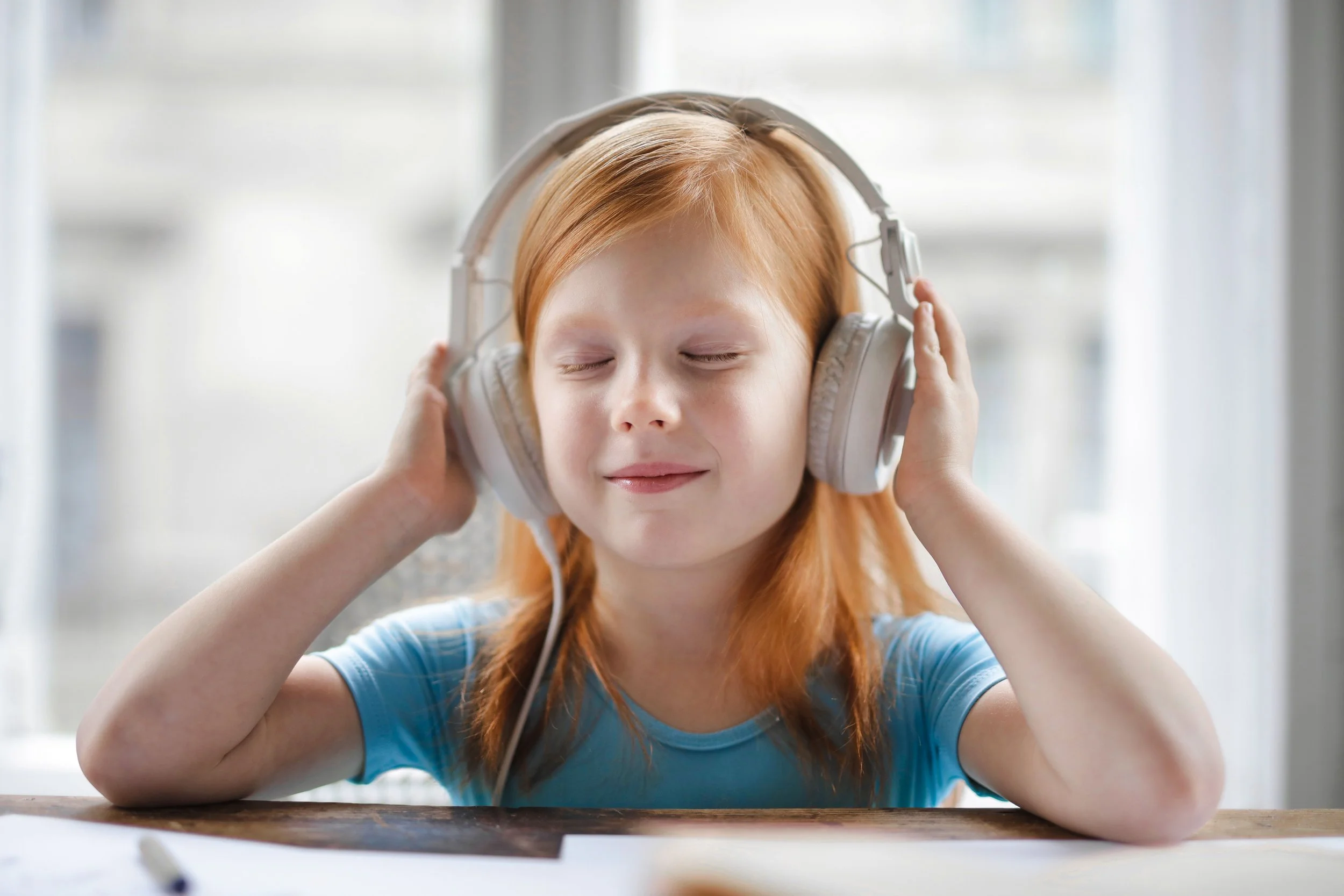 Child wearing headphones while sitting at a table