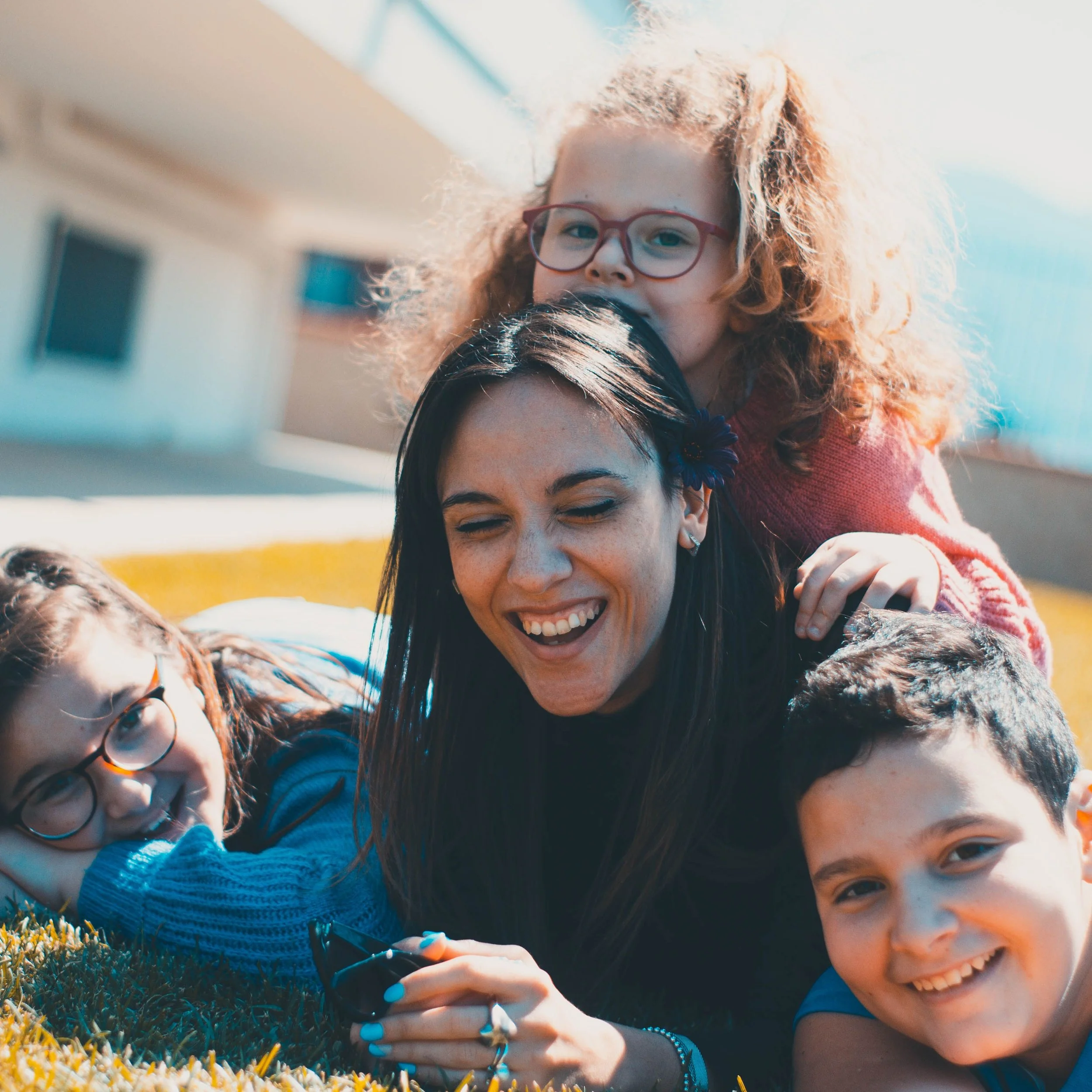 Four kids smiling laying on the grass