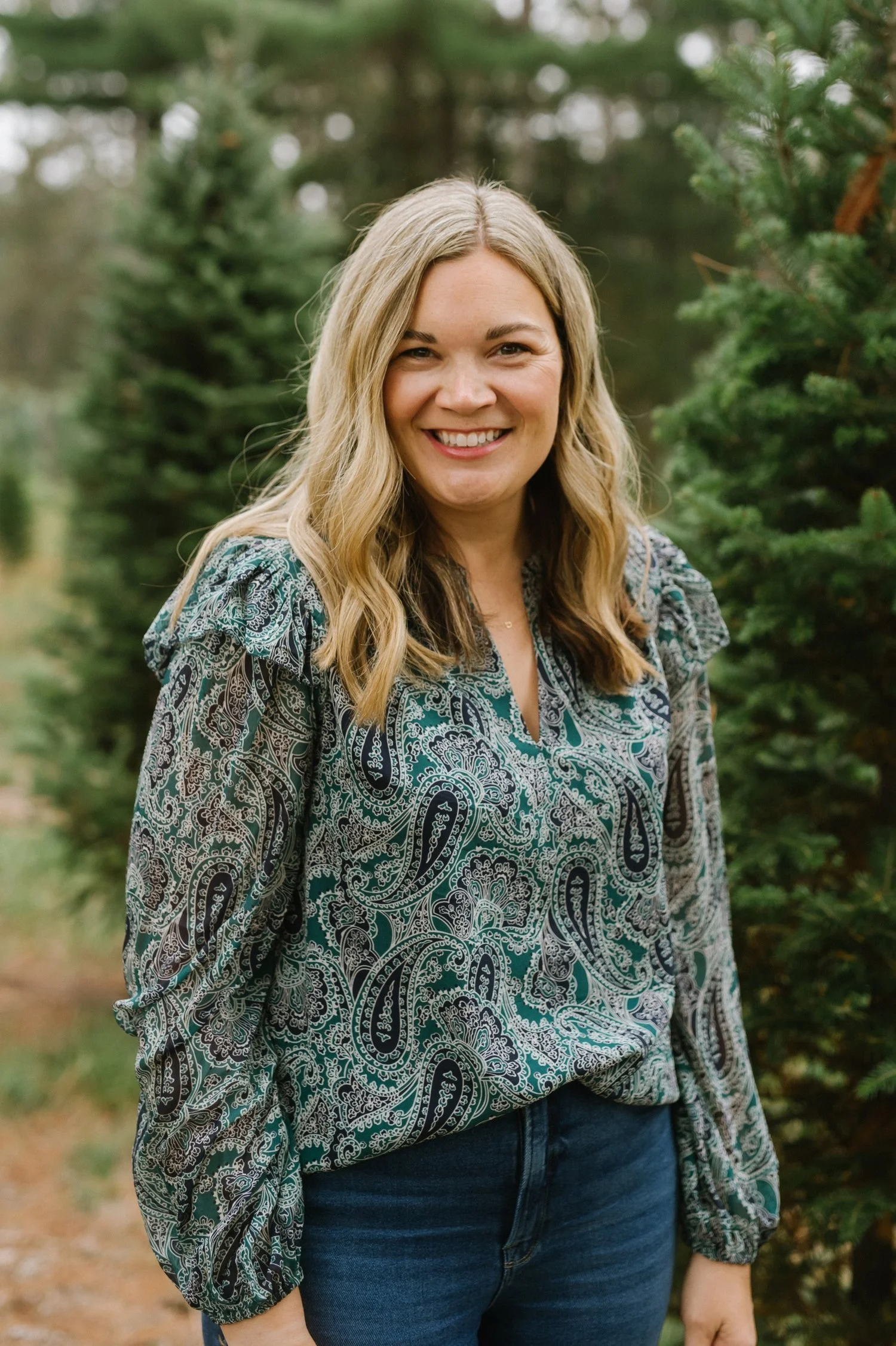 Therapist Liz Wienke standing and smiling with pine tress int the background