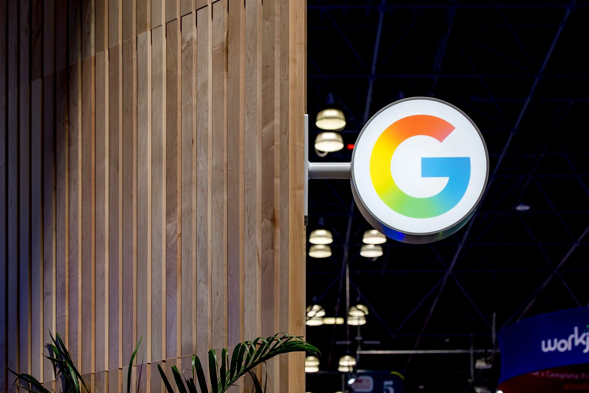Highlight of main booth entry illuminated sign featuring Google's gradient SuperG logo
