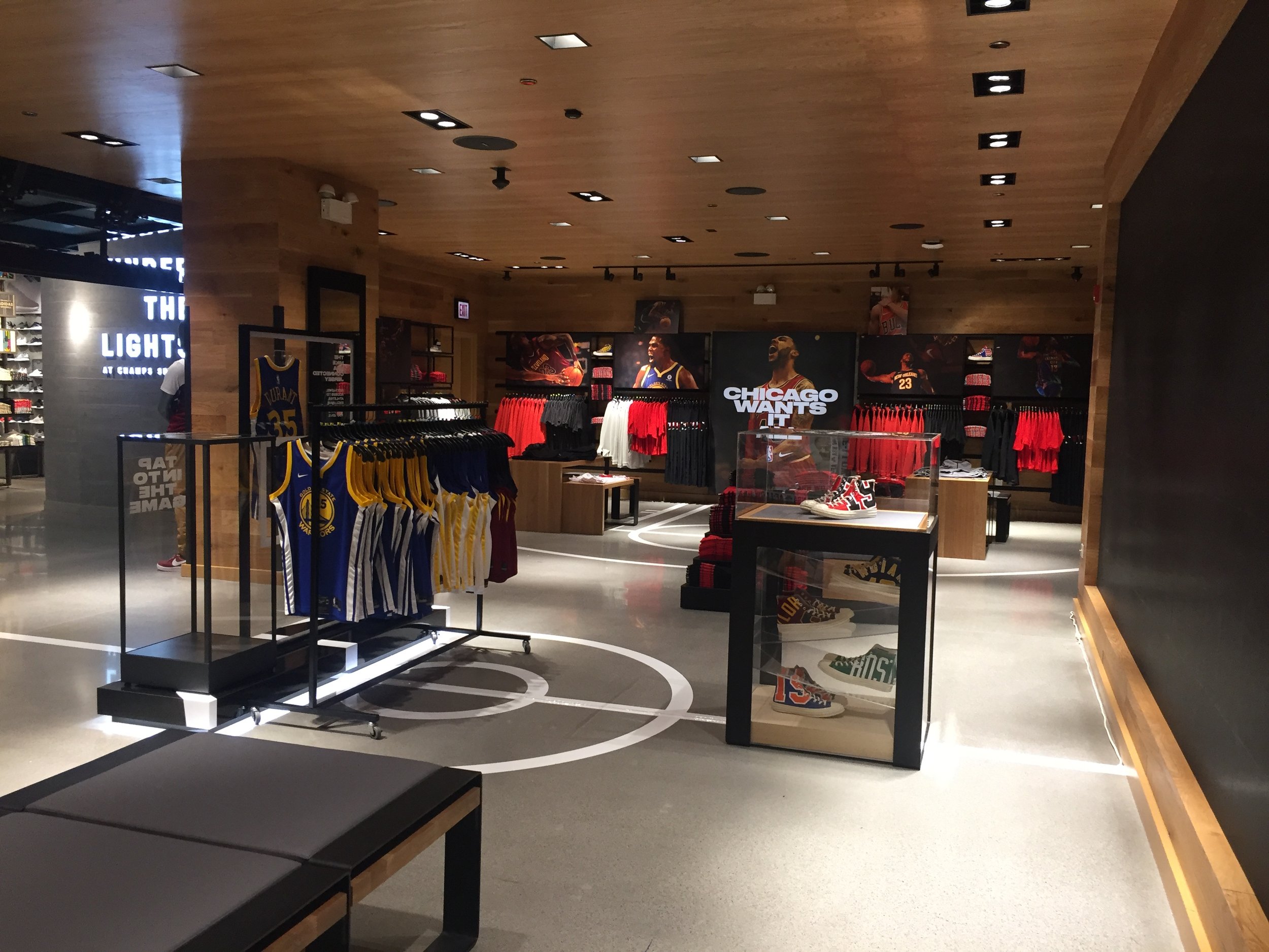 view of jerseys with Converse footwear pedestal in the foreground and Nike NBA fan apparel in the background