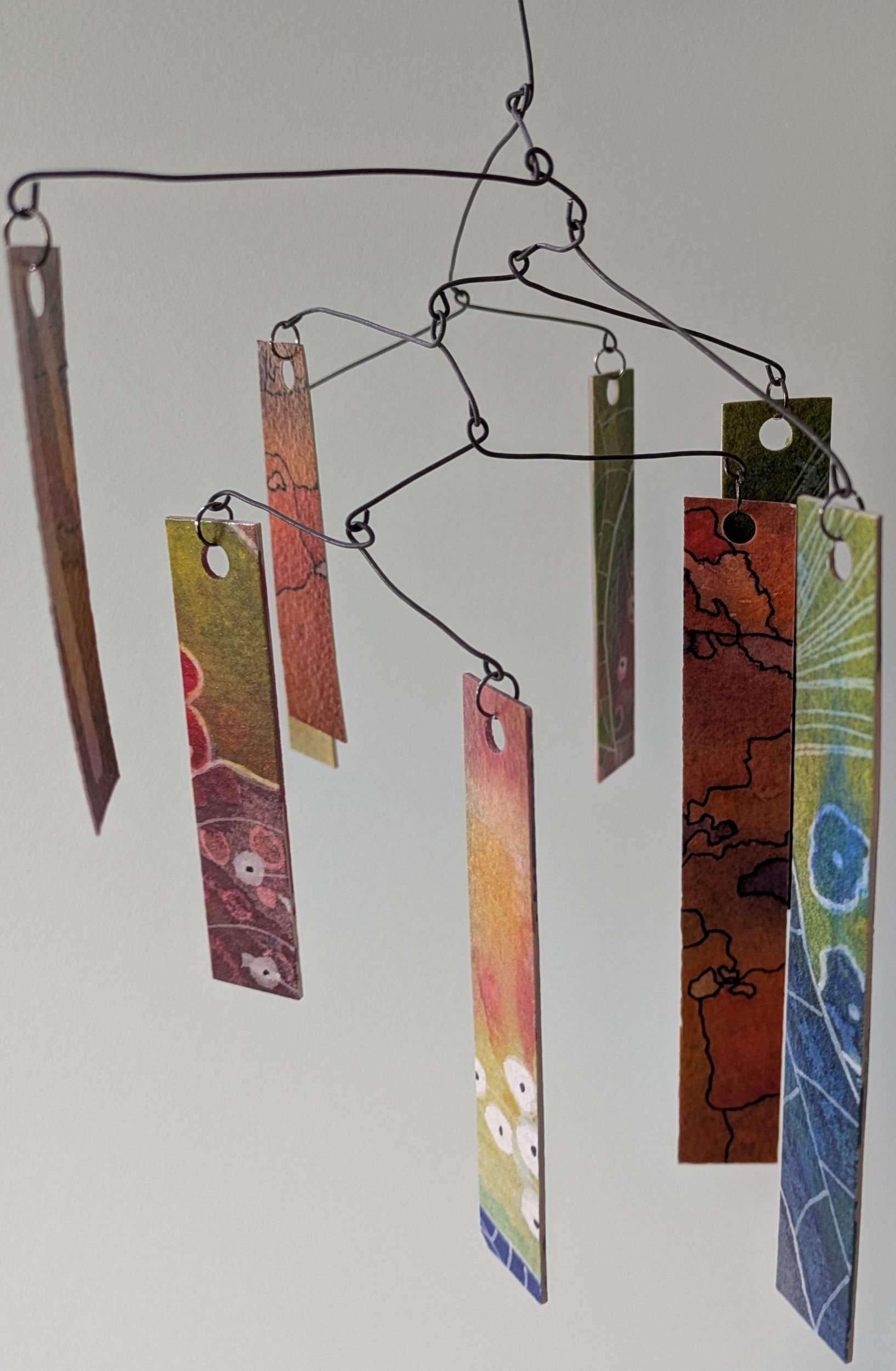 Colorful paper bookmarks hanging from a wire display.
