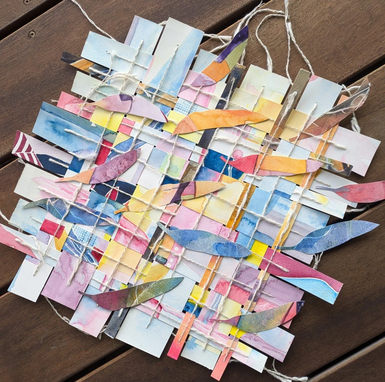 Colourful woven paper and string artwork, intertwined with leaf shapes, representing nesting time.