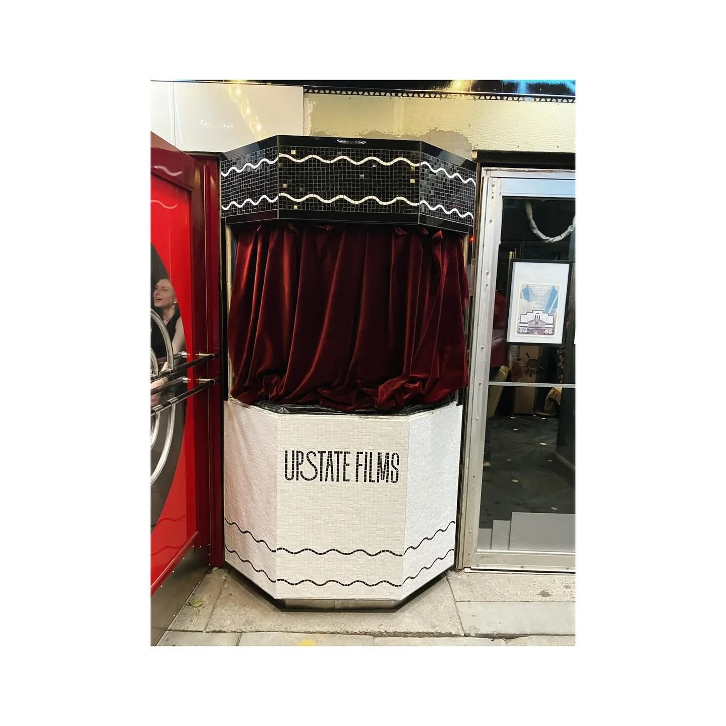 This mosaic, created for the Upstate Films movie theater booth, combines a sleek Art Deco-inspired design with modern craftsmanship. The white mosaic tiles form a clean geometric surface, accented by black wavy lines that wrap around the booth, creat