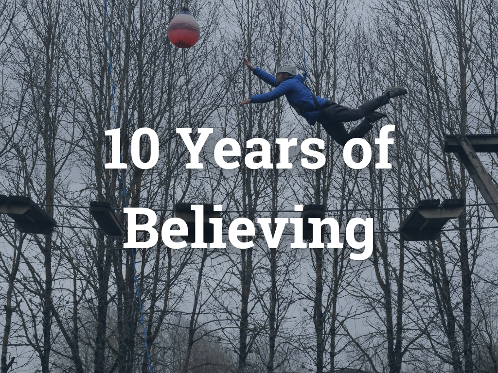 Text on a white background that reads '10 Years of Believing' in bold navy blue font.