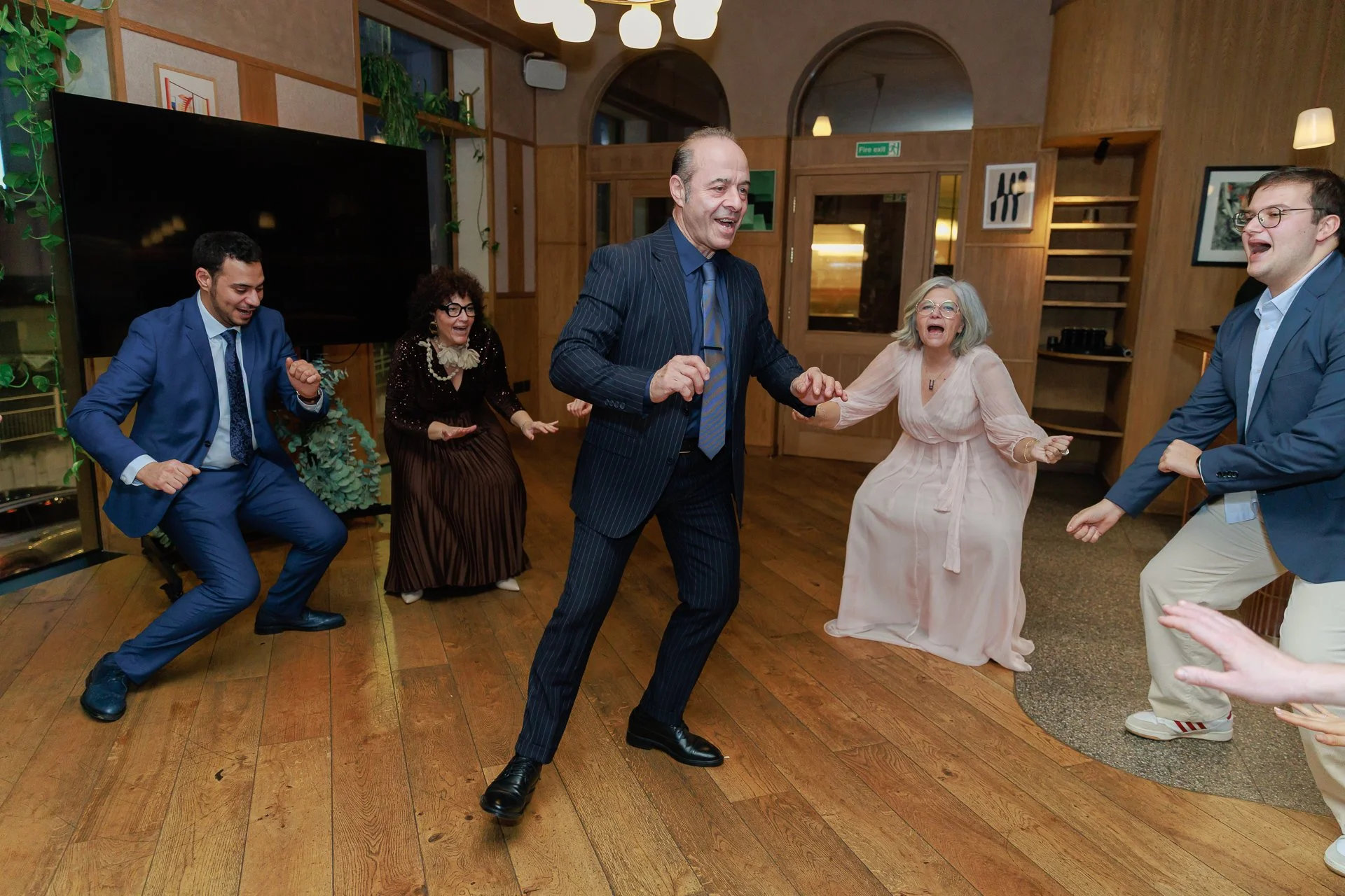 People dancing and enjoying themselves indoors at a social gathering or party.