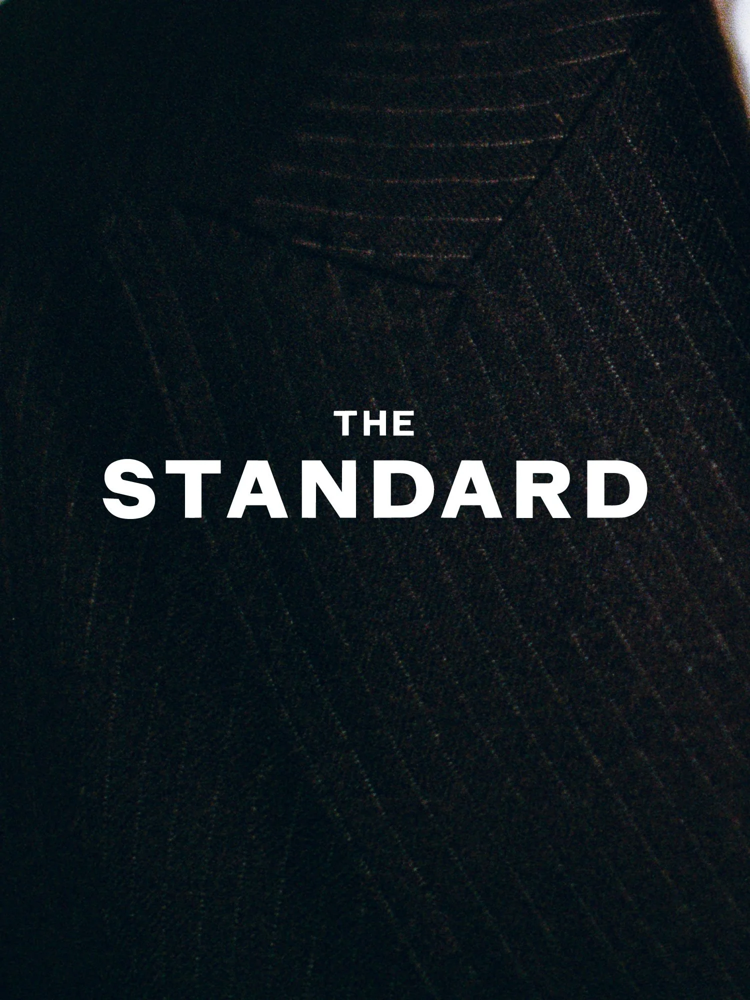 The cover of a publication called 'The Standard' with a dark background and subtle line pattern.