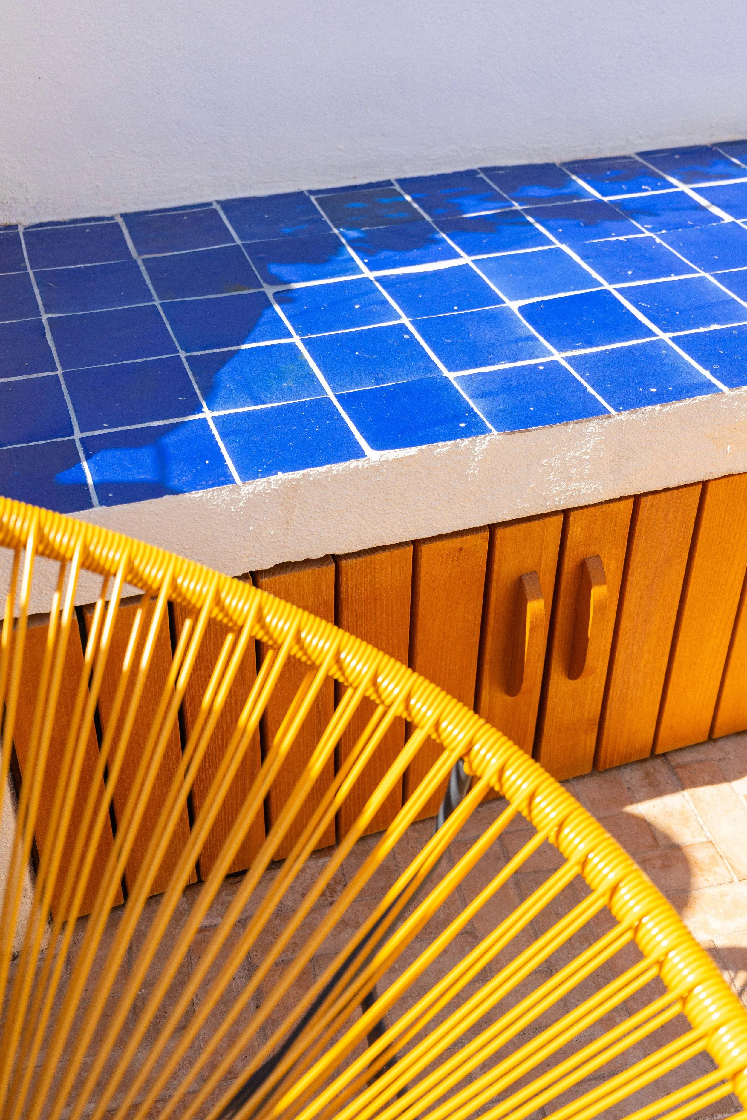 Aménagement complet d'une terrasse de toit à Marseille avec voile d'ombrage et mobilier jaune.
