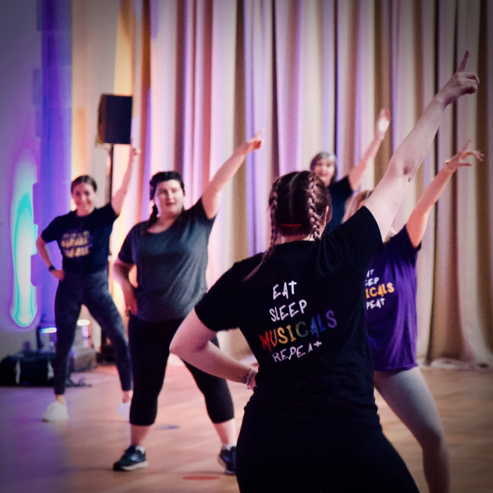 People in a dance studio following instructions from a teacher