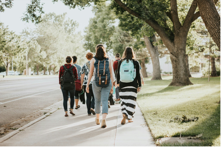 Students walking on an ordinary campus street, representing the calm before a behavioral deviation is noticed