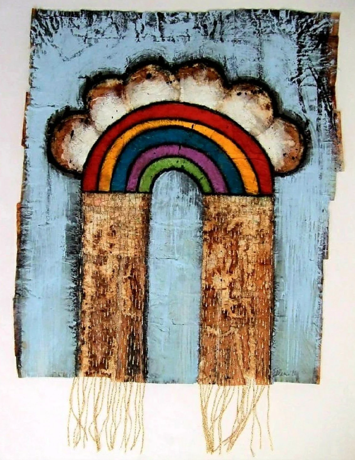 A rustic texti art piece featuring a painted rainbow with five colors (red, orange, blue, purple, green), surrounded by a cloud and a sun design. The rainbow arches over a brown and light blue background, with golden threads hanging from the bottom.