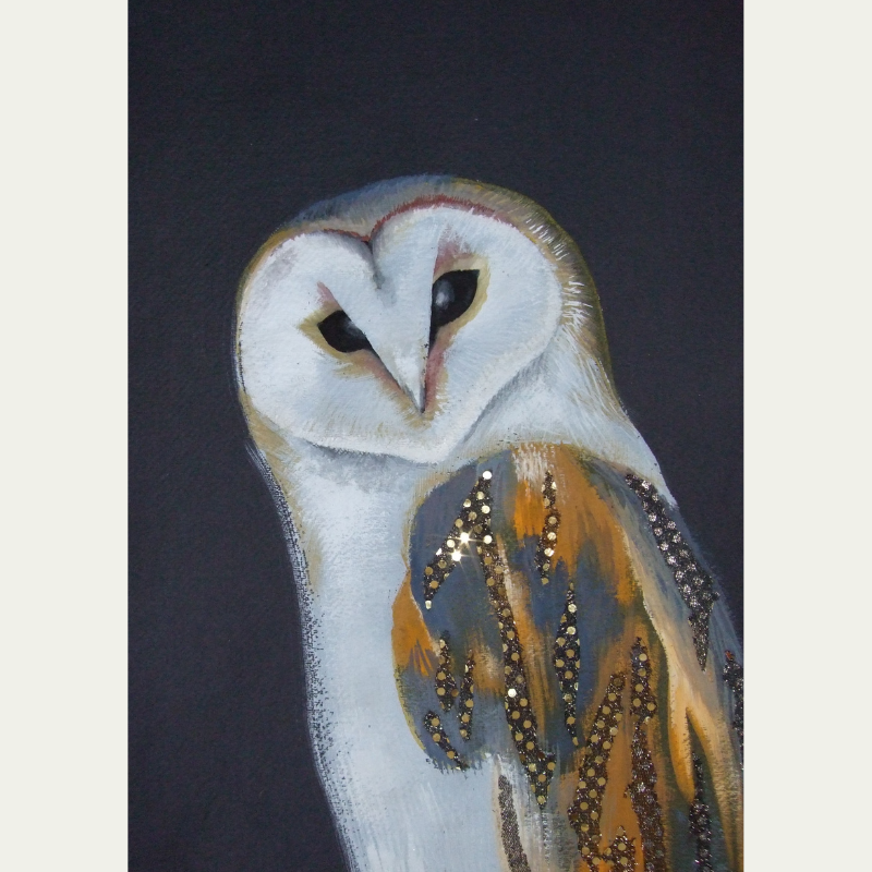 Painting of a barn owl with a white face and dark eyes on a black background, decorated with gold and black glitter accents on its feathers.