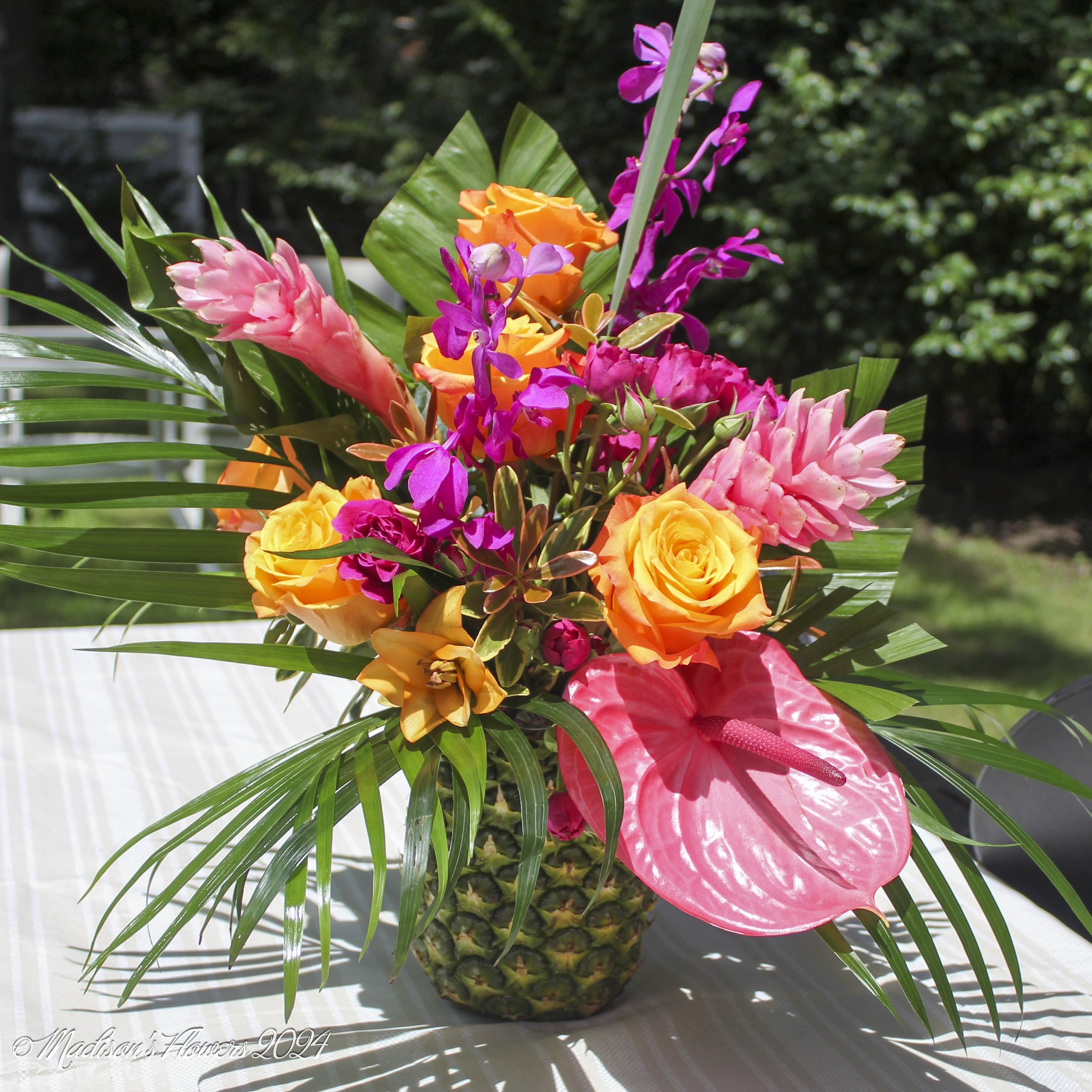 Calypso Mokara Orchids in Fucshia, Pink anthuriums, Golden Aloha Roses, Pink ginger, and yellow lilies.