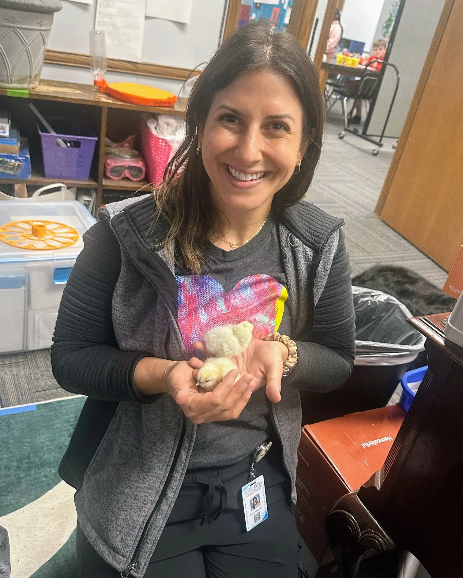 Mental health counselor Kaley holds chicks hatched in the science classroom