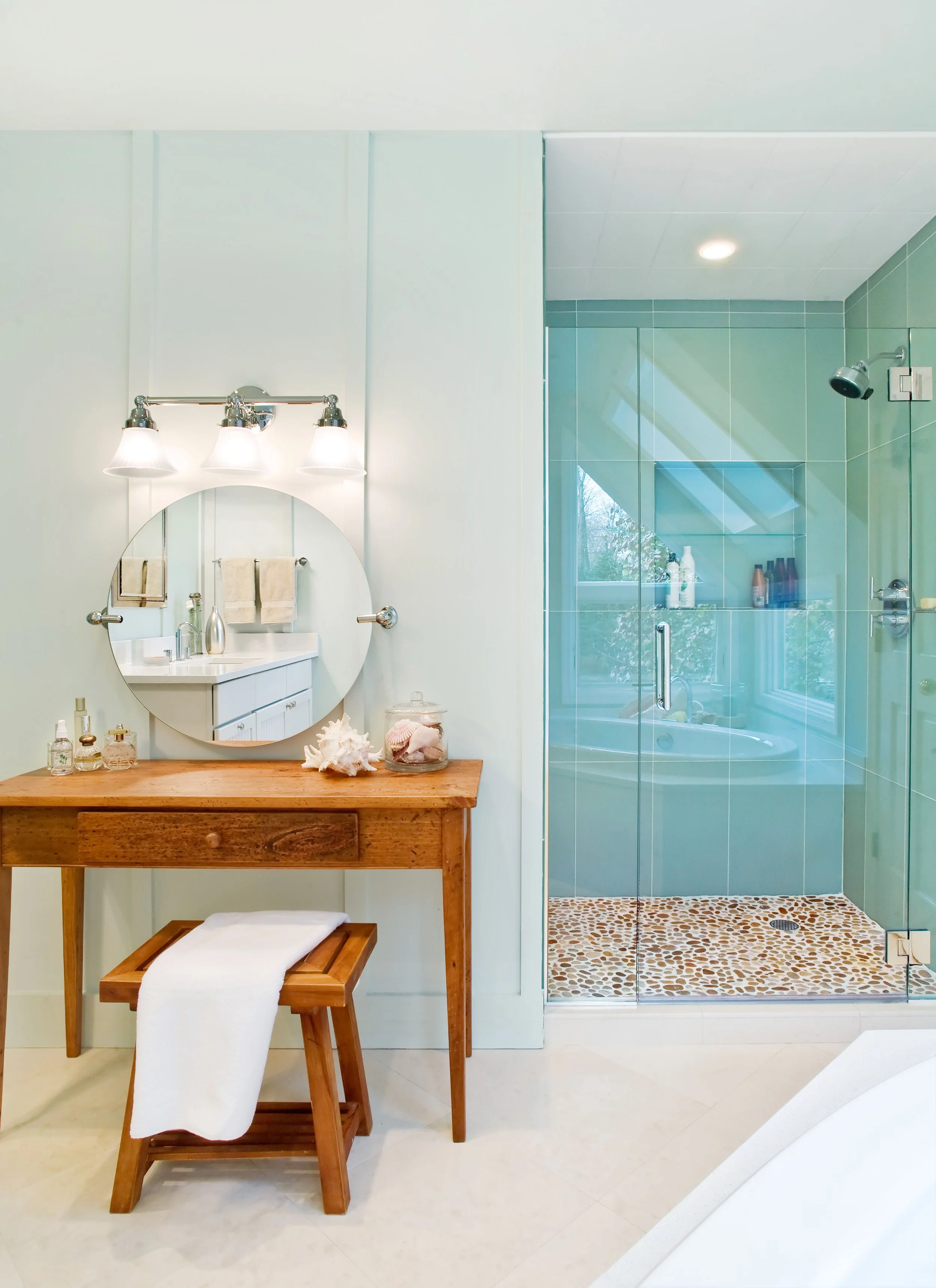 Primary bathroom design in Pleasantville, NY featuring a custom vanity and glass-enclosed shower by Luminosus Designs.