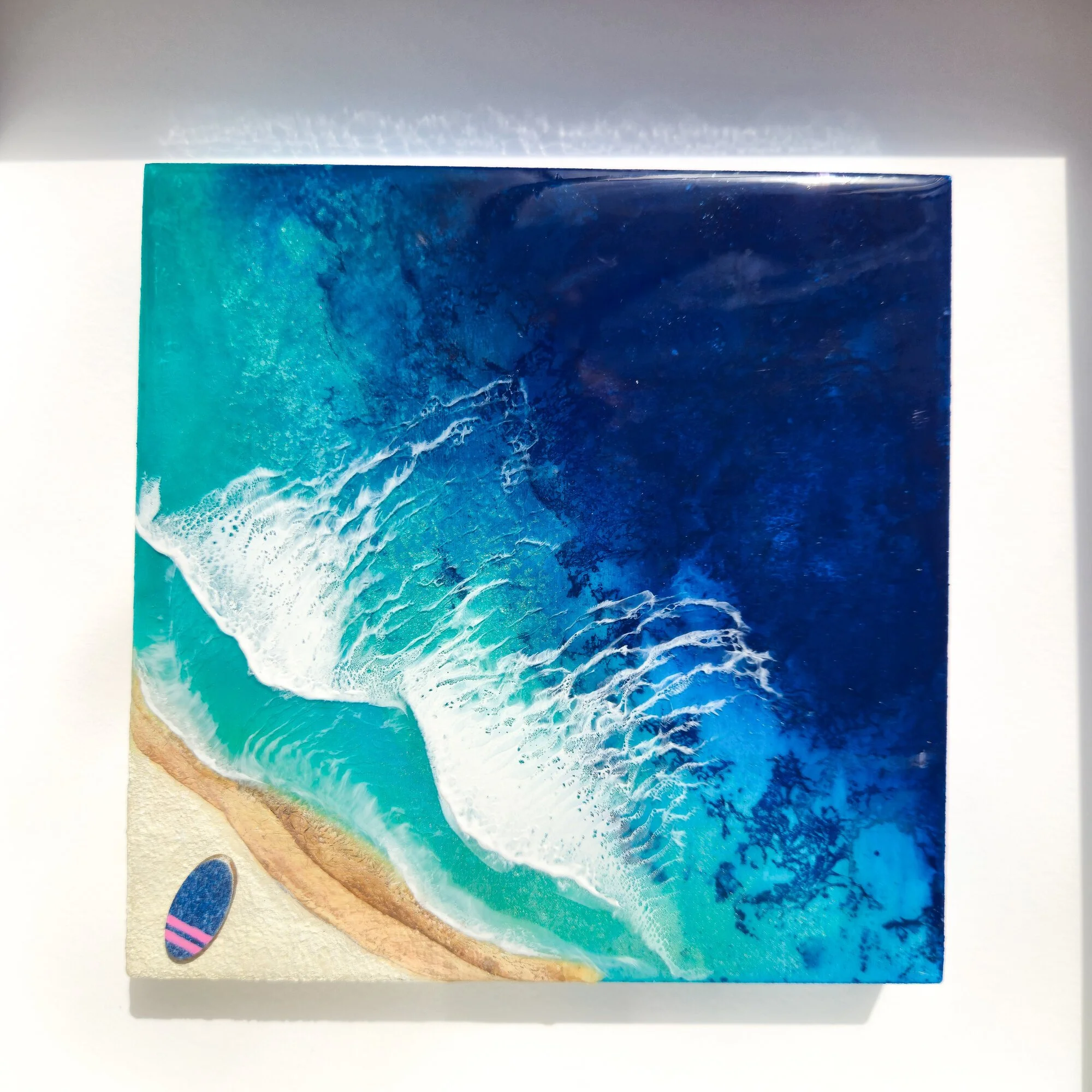 Never Stop Dreaming framed resin artwork positioned in a modern interior with coastal styling
