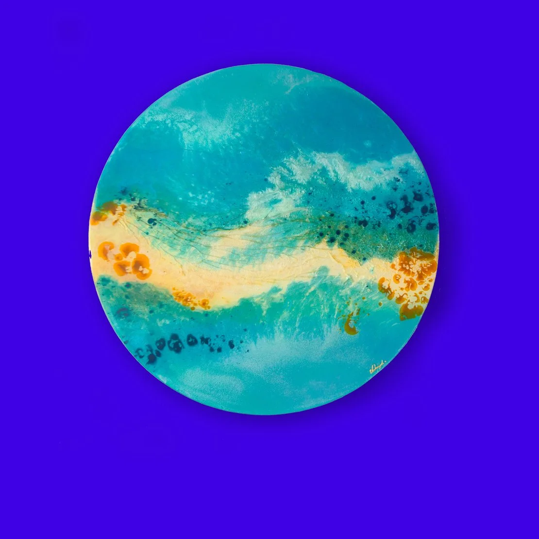 Round resin artwork with golden sand and ocean blues titled Salt of the Earth.