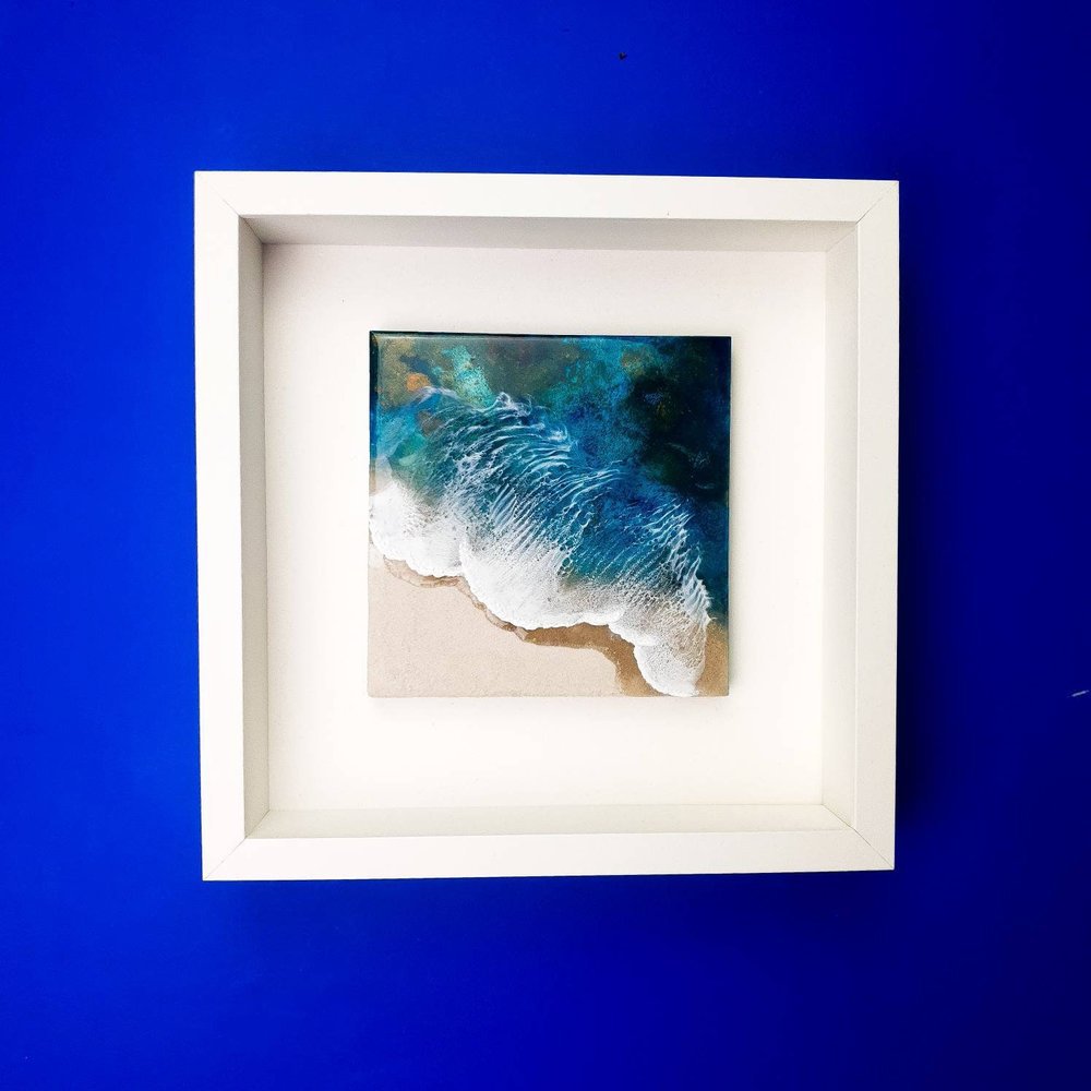 Resin artwork featuring vibrant blue ocean waves and real sand, ocean inspired.