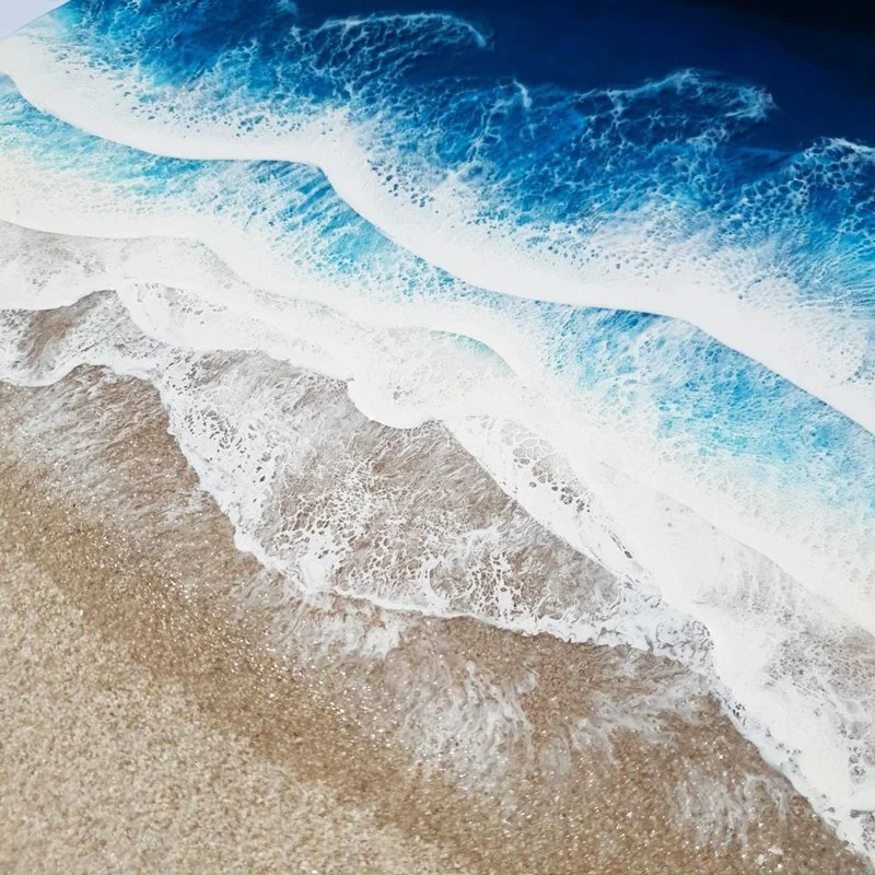 Close up of ocean-inspired resin painting with turquoise and emerald tones, capturing abstract beach beauty.