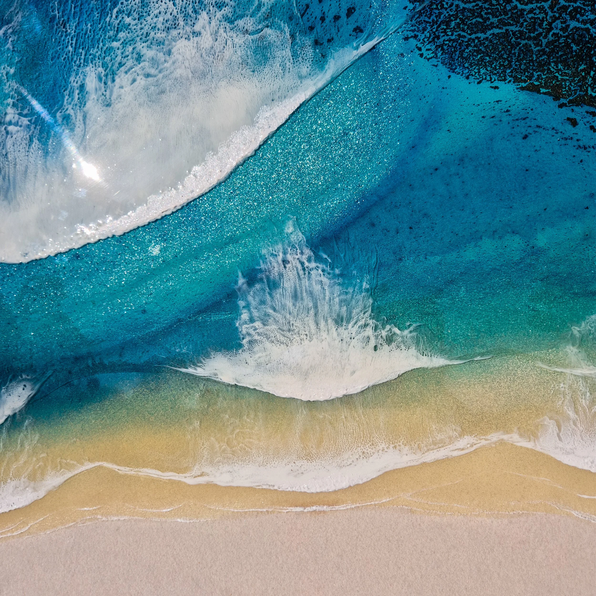 Large round resin artwork with swirling blue ocean textures and sandy shoreline, featuring a high-gloss finish on wood panel.
