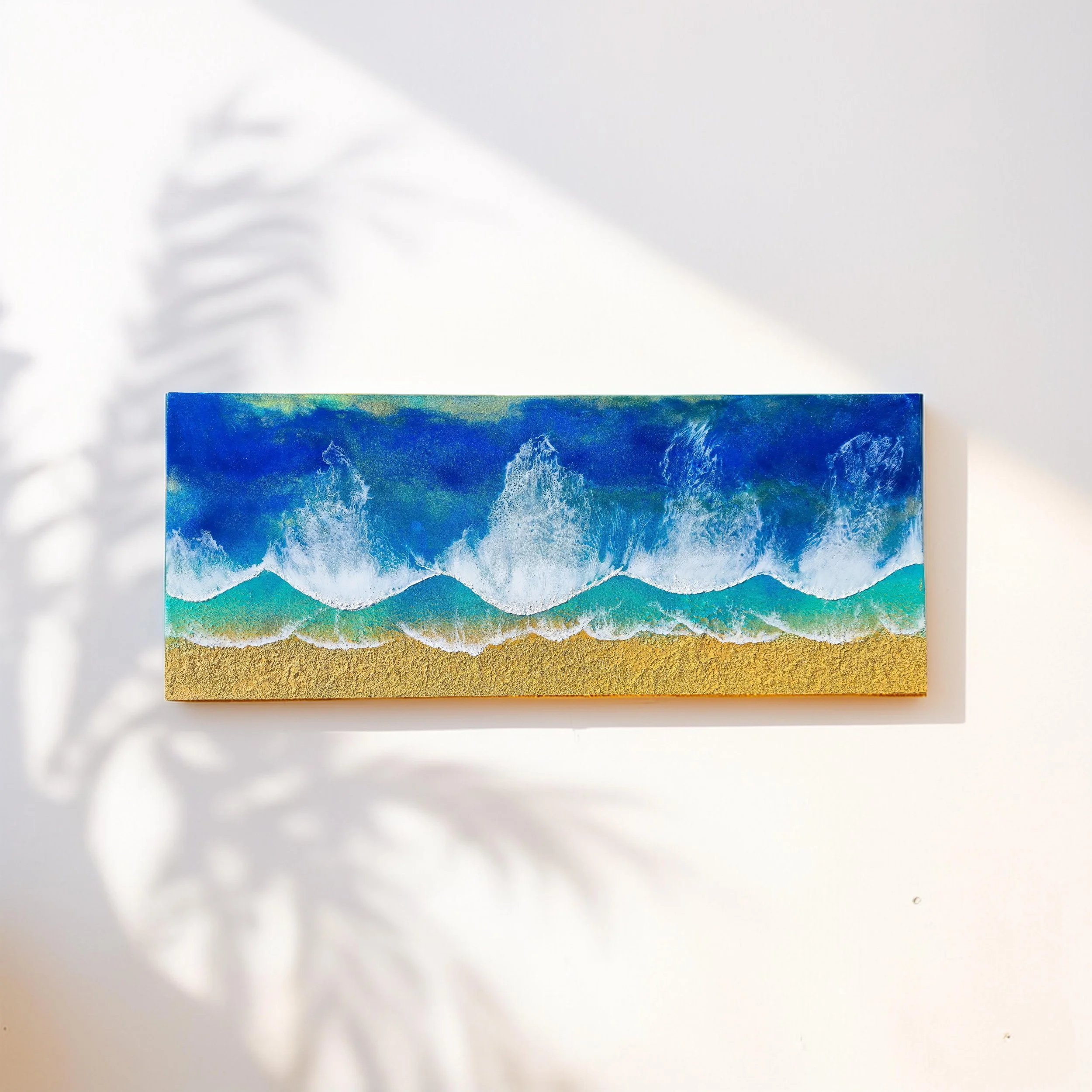 Rectangular ocean wall art with four rolling waves in deep blue, turquoise, and golden sand on textured shoreline.