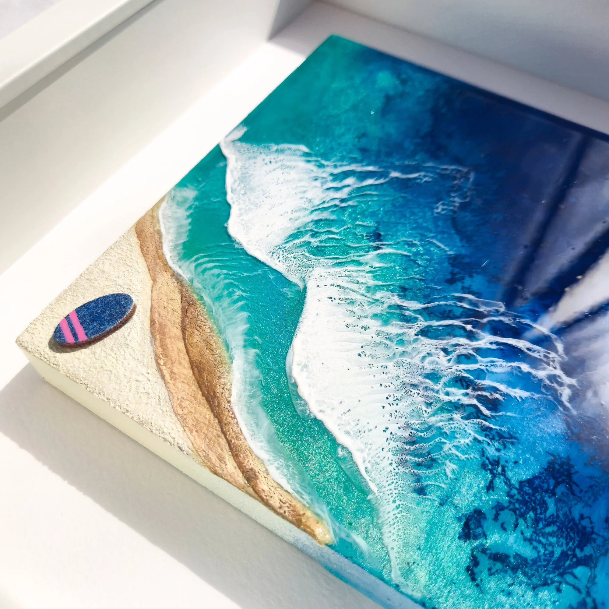 Framed Never Stop Dreaming resin artwork displayed on a living room wall above a white console