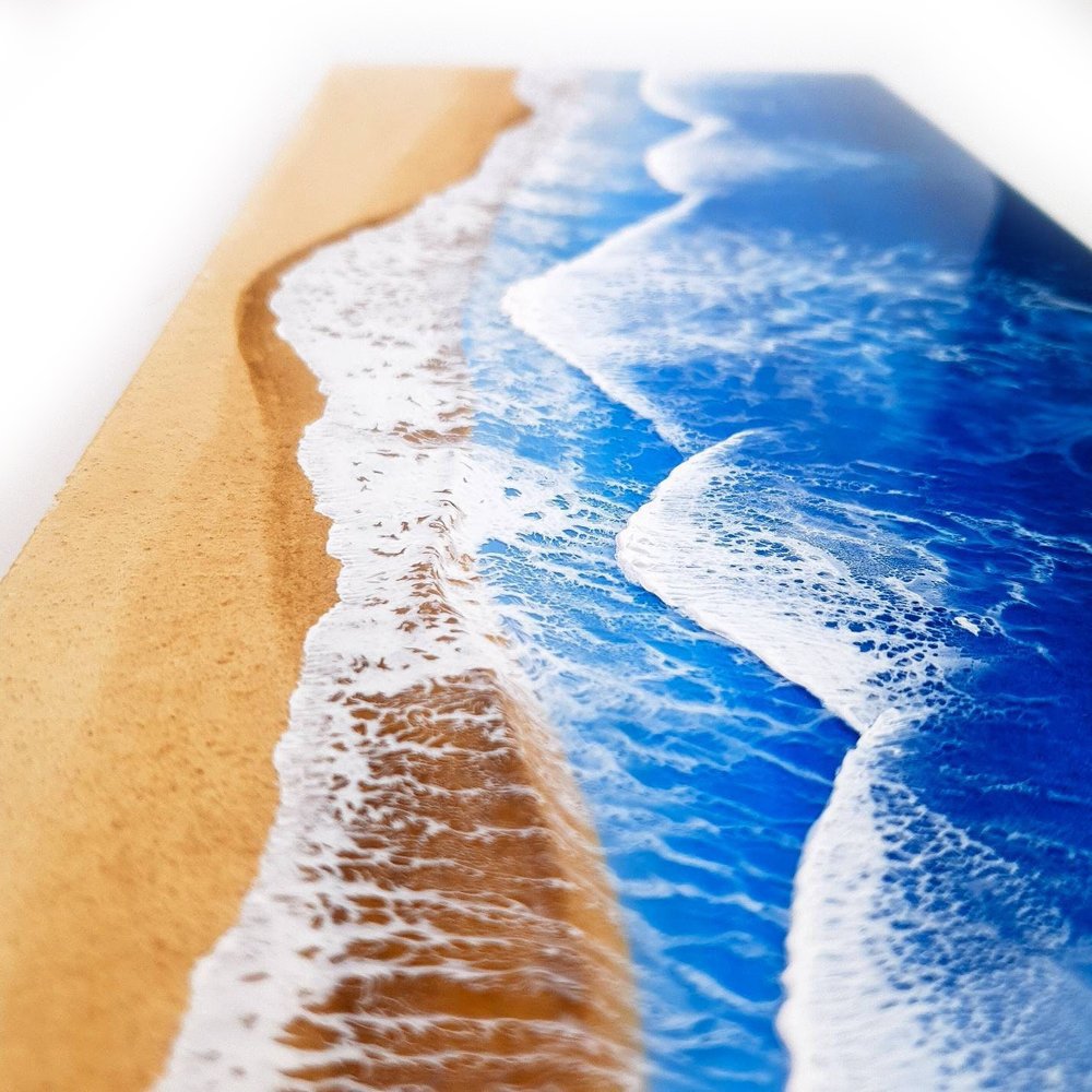 Resin artwork featuring vibrant blue ocean waves and sand tones, ocean inspired.