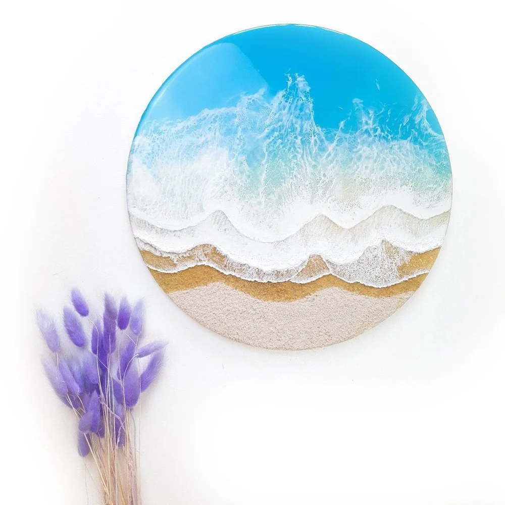 Resin artwork featuring vibrant blue ocean waves and sand tones, ocean inspired.