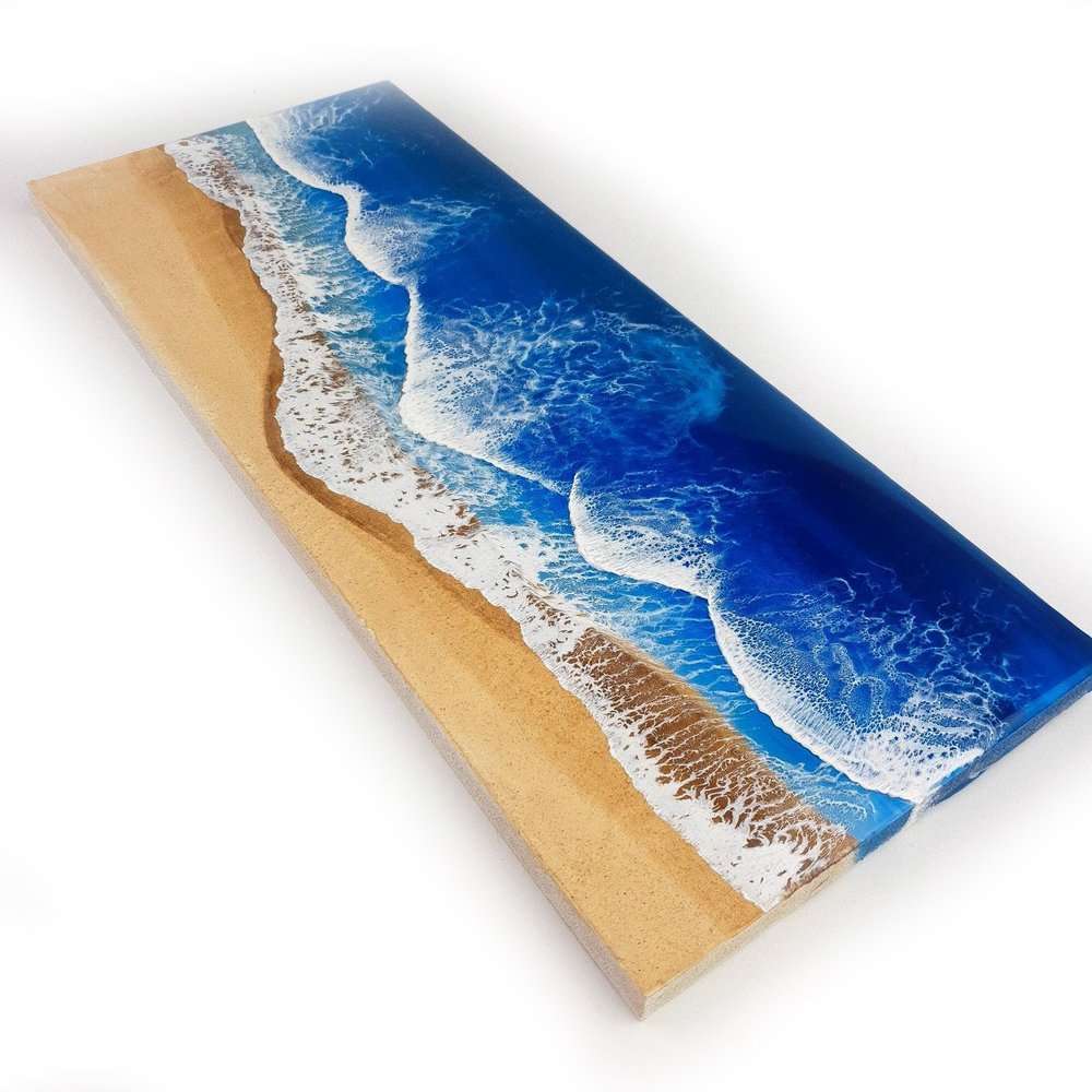 Resin artwork featuring vibrant blue ocean waves and sand tones, ocean inspired.