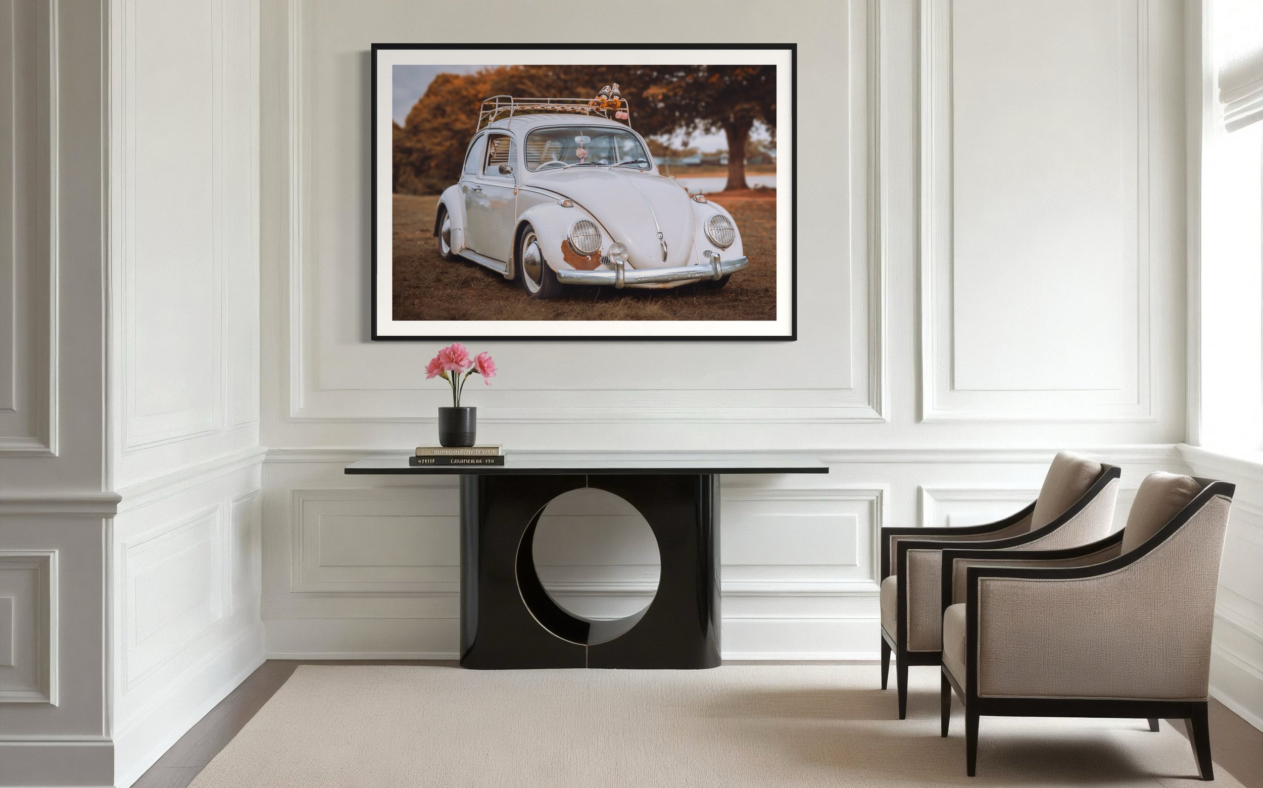 Elegant living room with white panel walls, a console table, and two chairs. A large framed photograph of a vintage car is displayed on the wall.