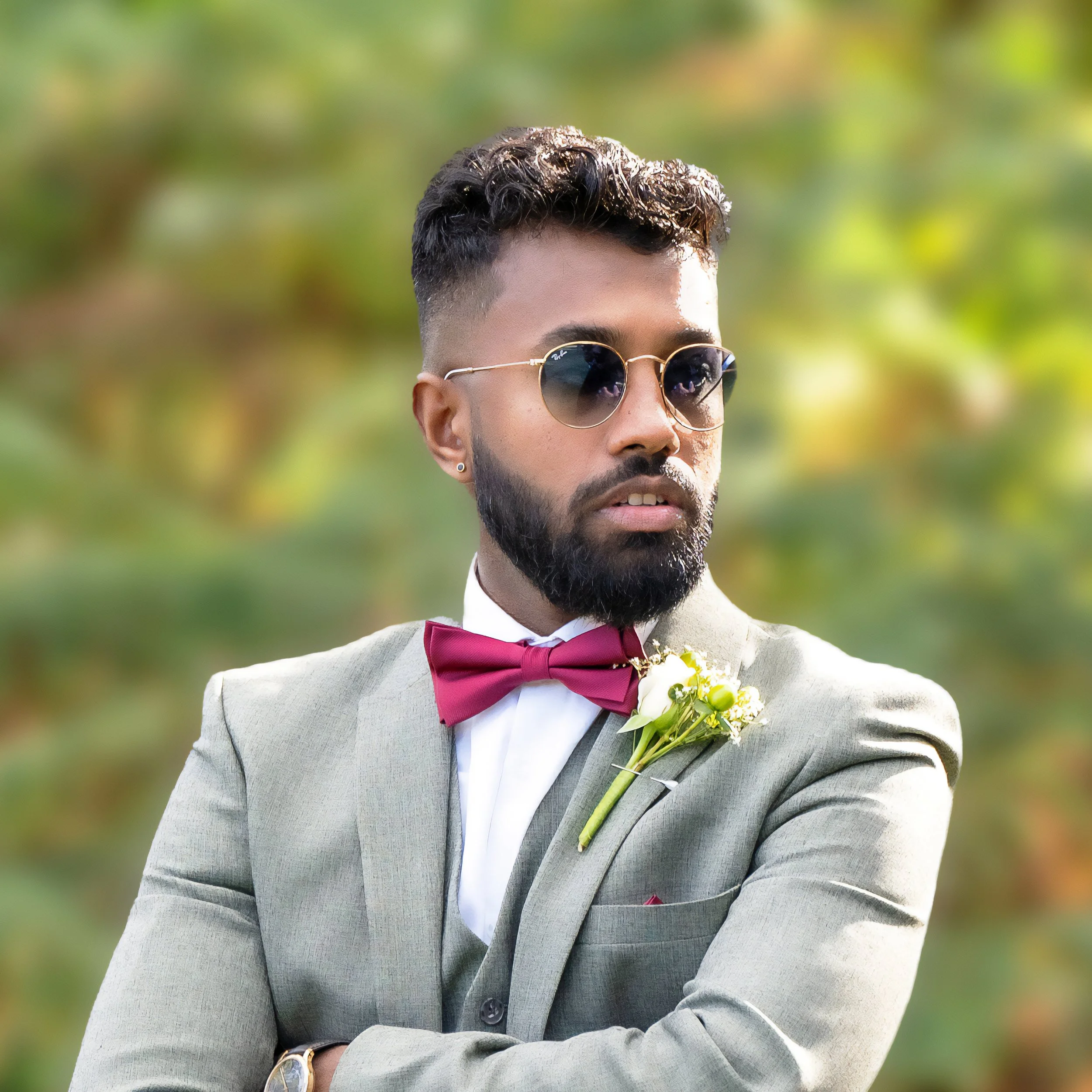 Man in suit with sunglasses and bow tie, outdoors