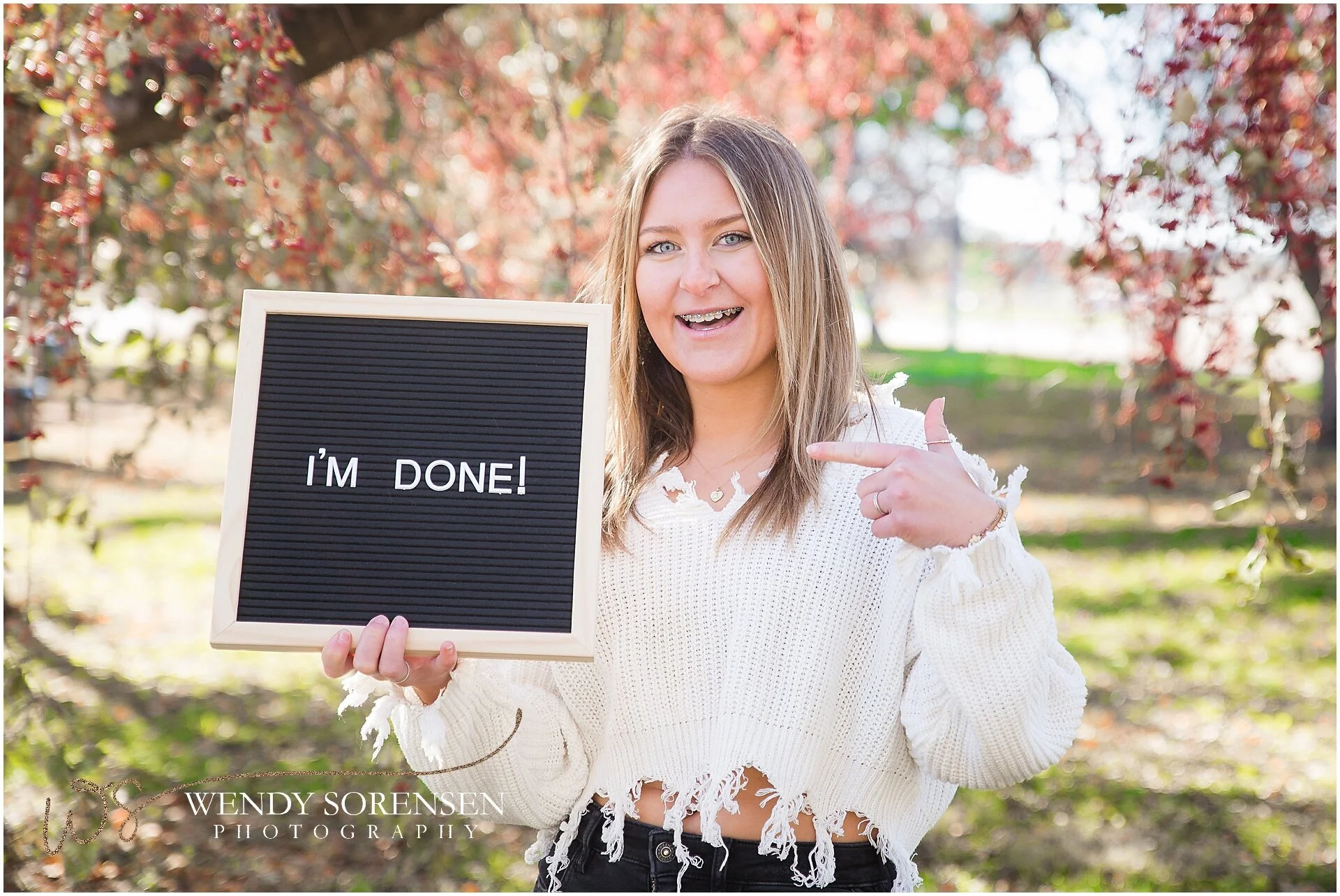 Senior girl holding a letter board saying "I'm done!" in Des Moines.