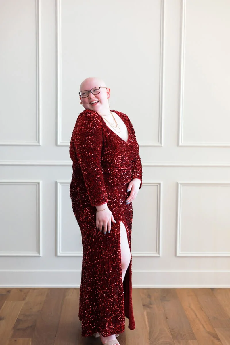 Senior girl wearing sunning floor length red sequin prom dress with front slit, photo by Wendy Sorensen, a Des Moines senior photographer.
