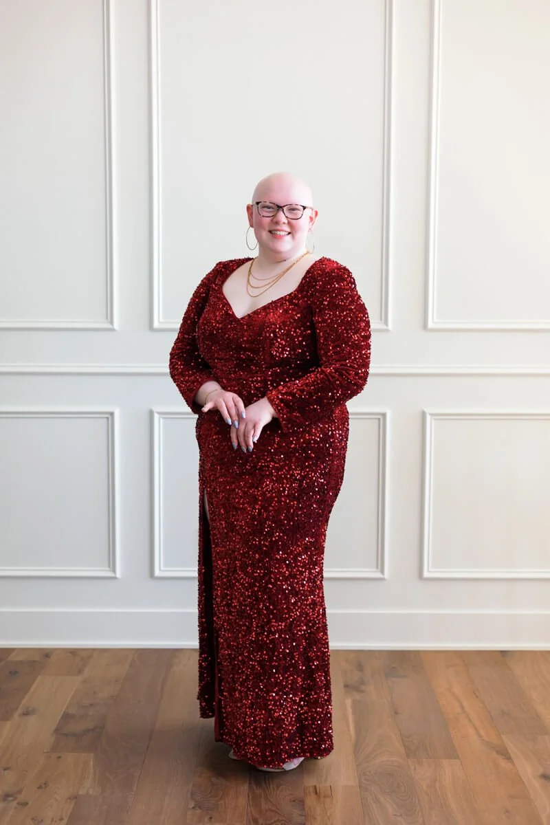 High school senior girl wearing long sleeved deep red sparlke prom dress.