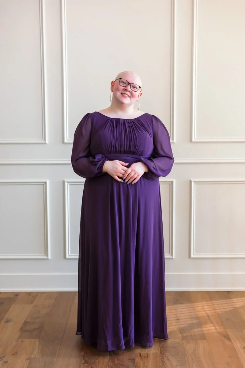 Senior girl in floor length eggplant prom dress.
