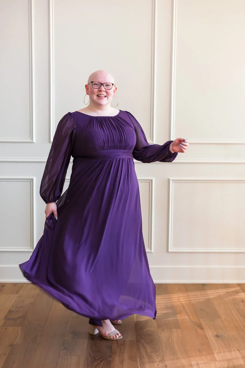 Senior girl twirling in purple long sleeved prom dress, photo by Wendy Sorensen, a Des Moines senior photographer.