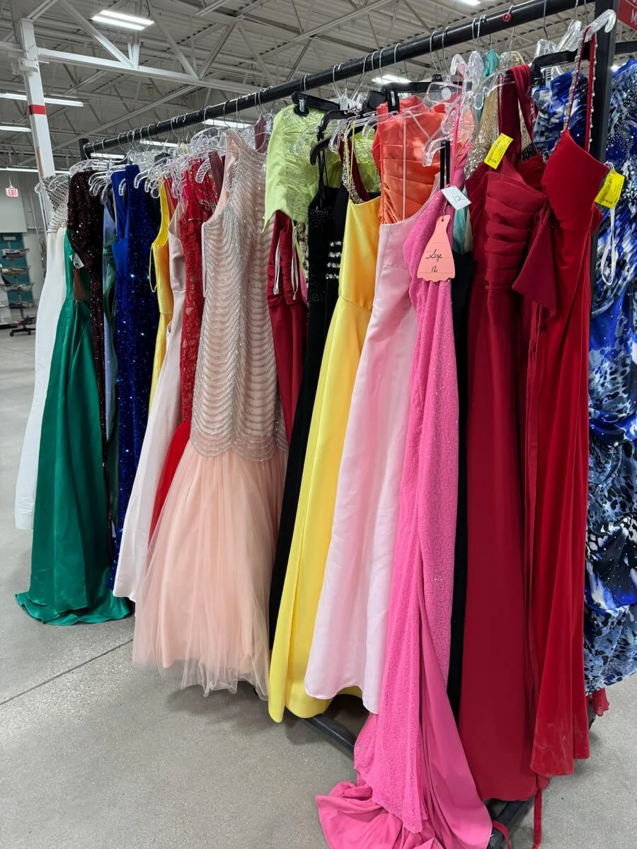Rack of second hand prom dresses at Many Hands Thrift Market in Clive.
